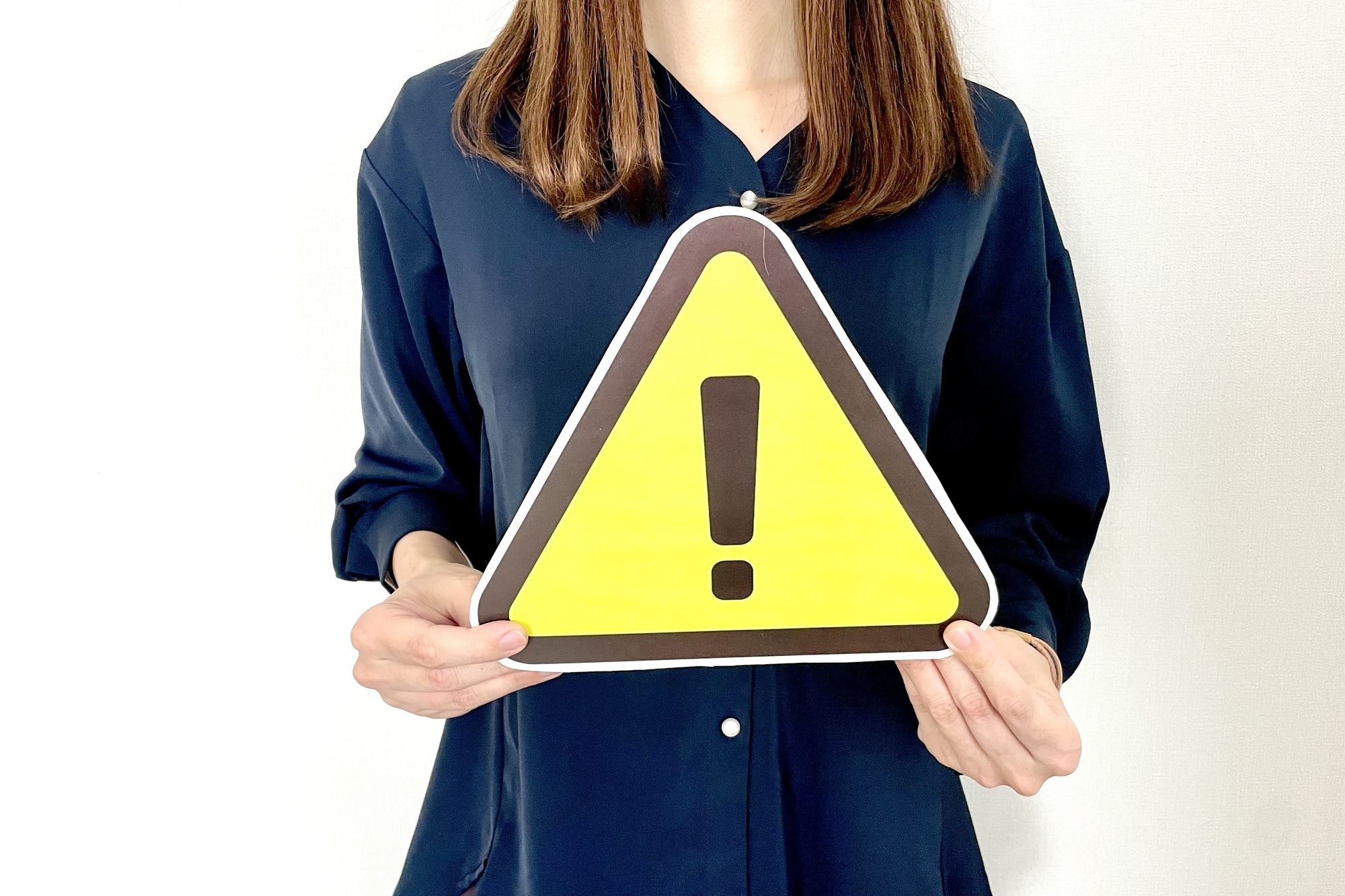 エクスクラメーションマークが印刷されたステッカーを手に持つ女性