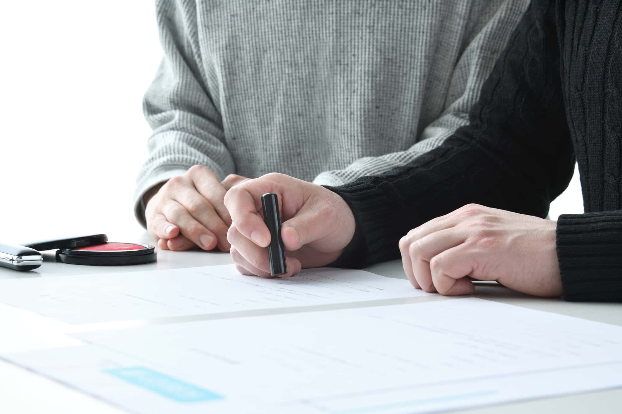 捺印をする男性とそれを見守る女性の手元