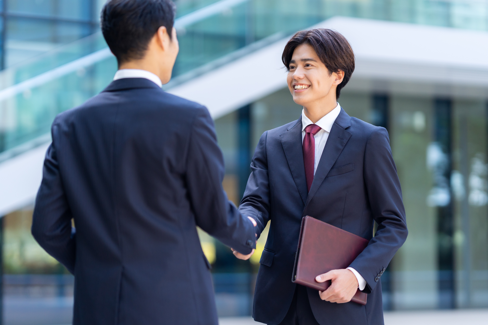 笑顔で握手をする2人のビジネスパーソン