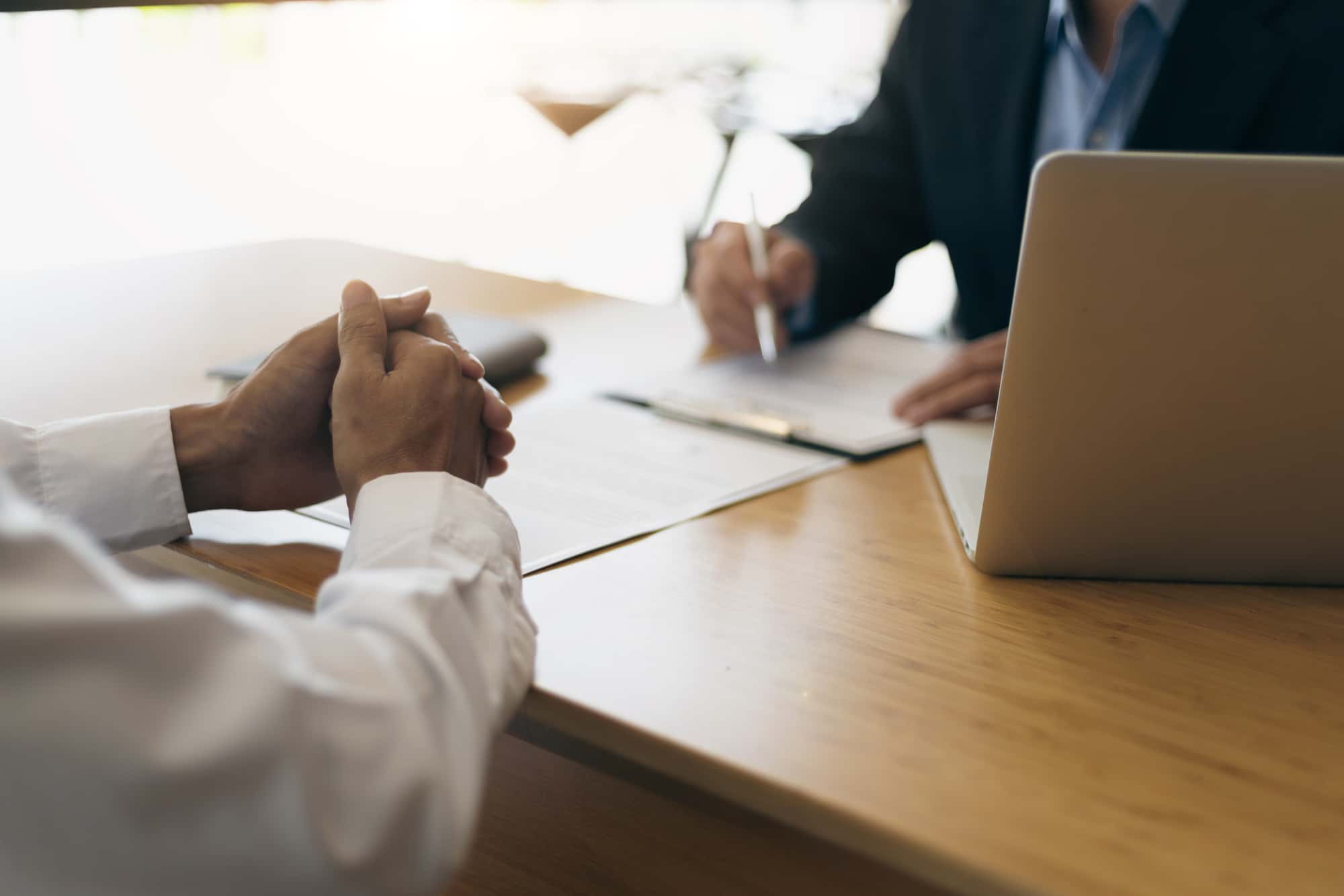 書類にサインしている人とそれを見ている人