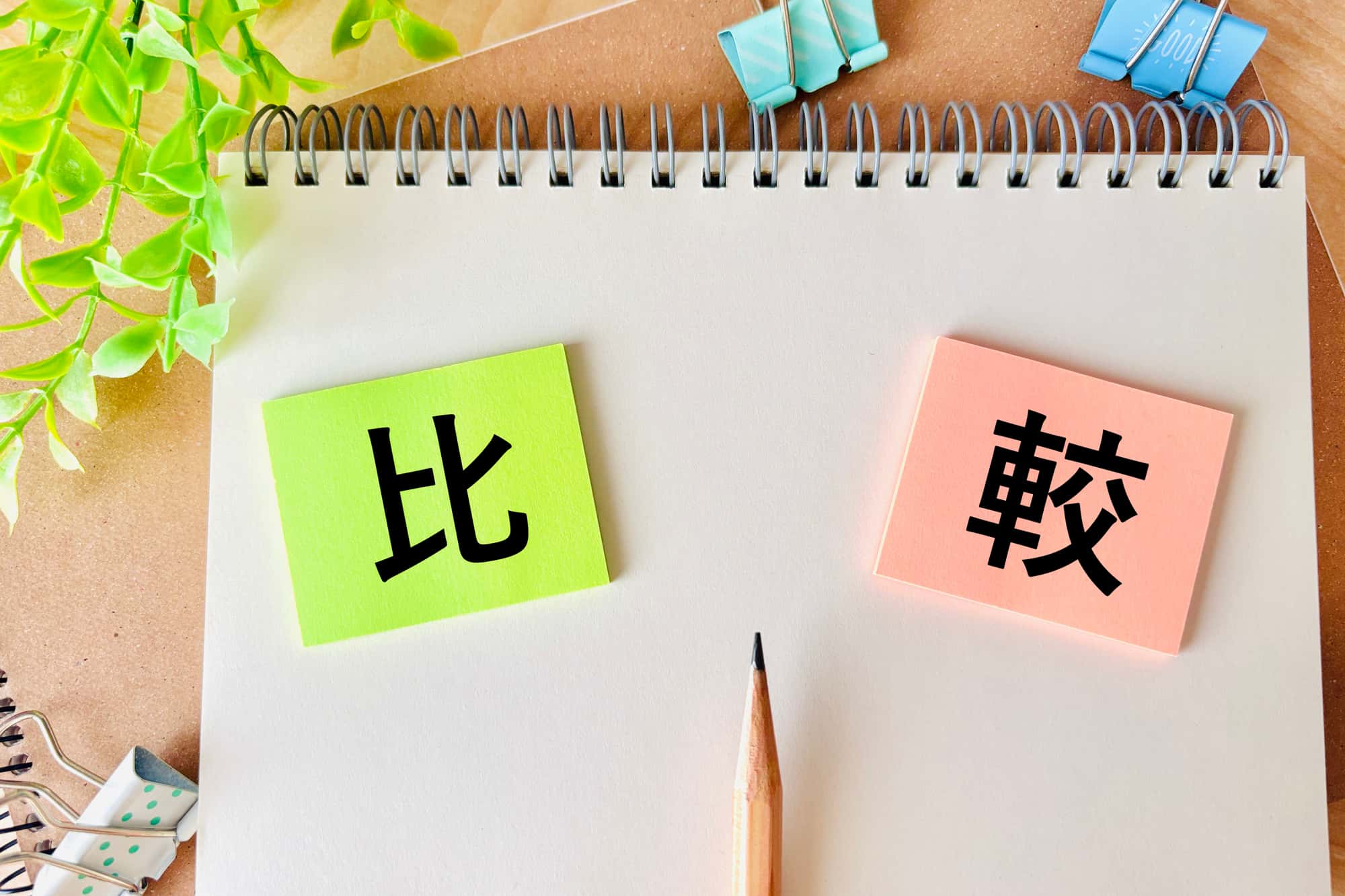 比較と書かれた付箋と鉛筆