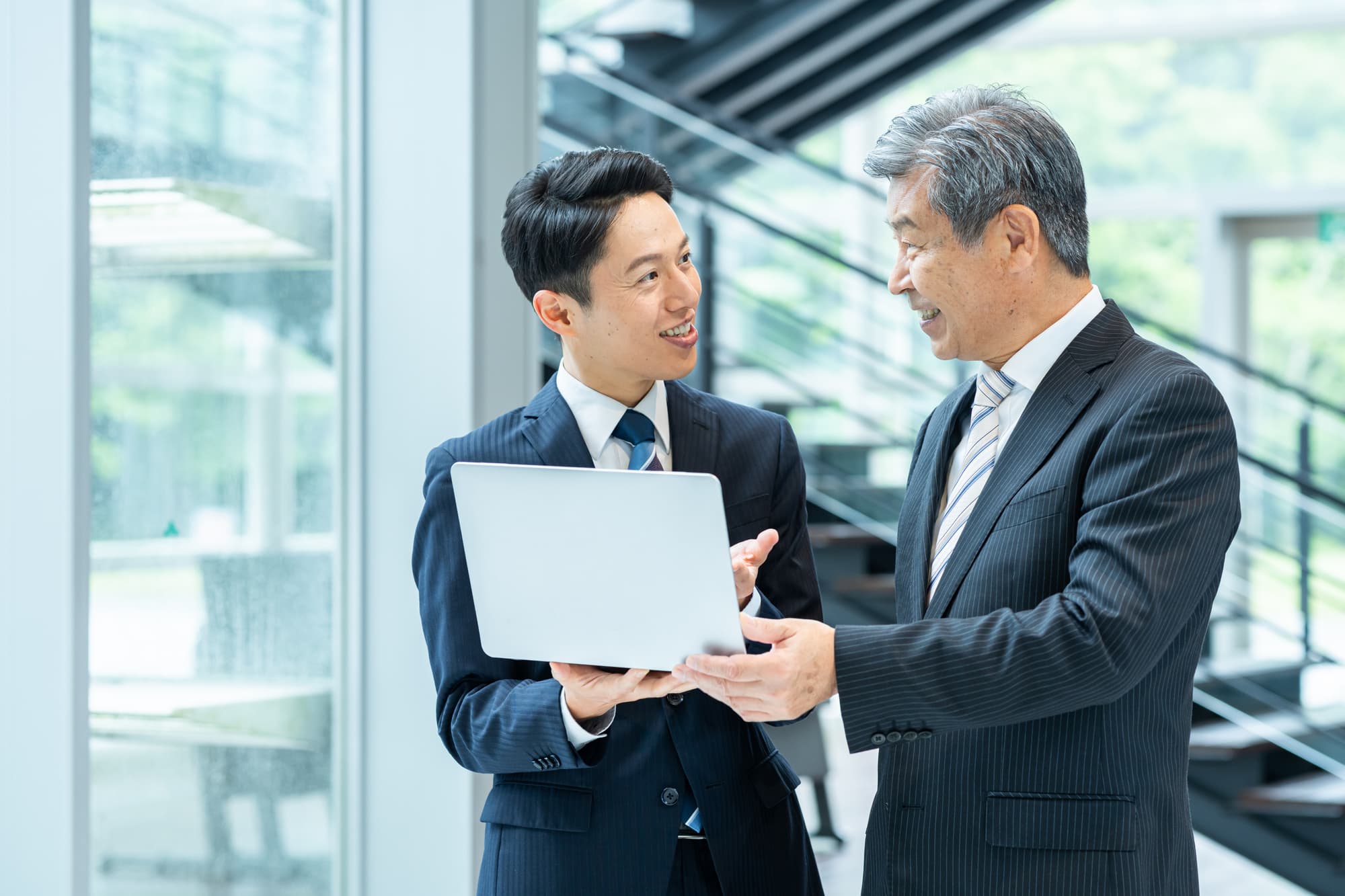 笑顔で打ち合わせしている2人のビジネスパーソン
