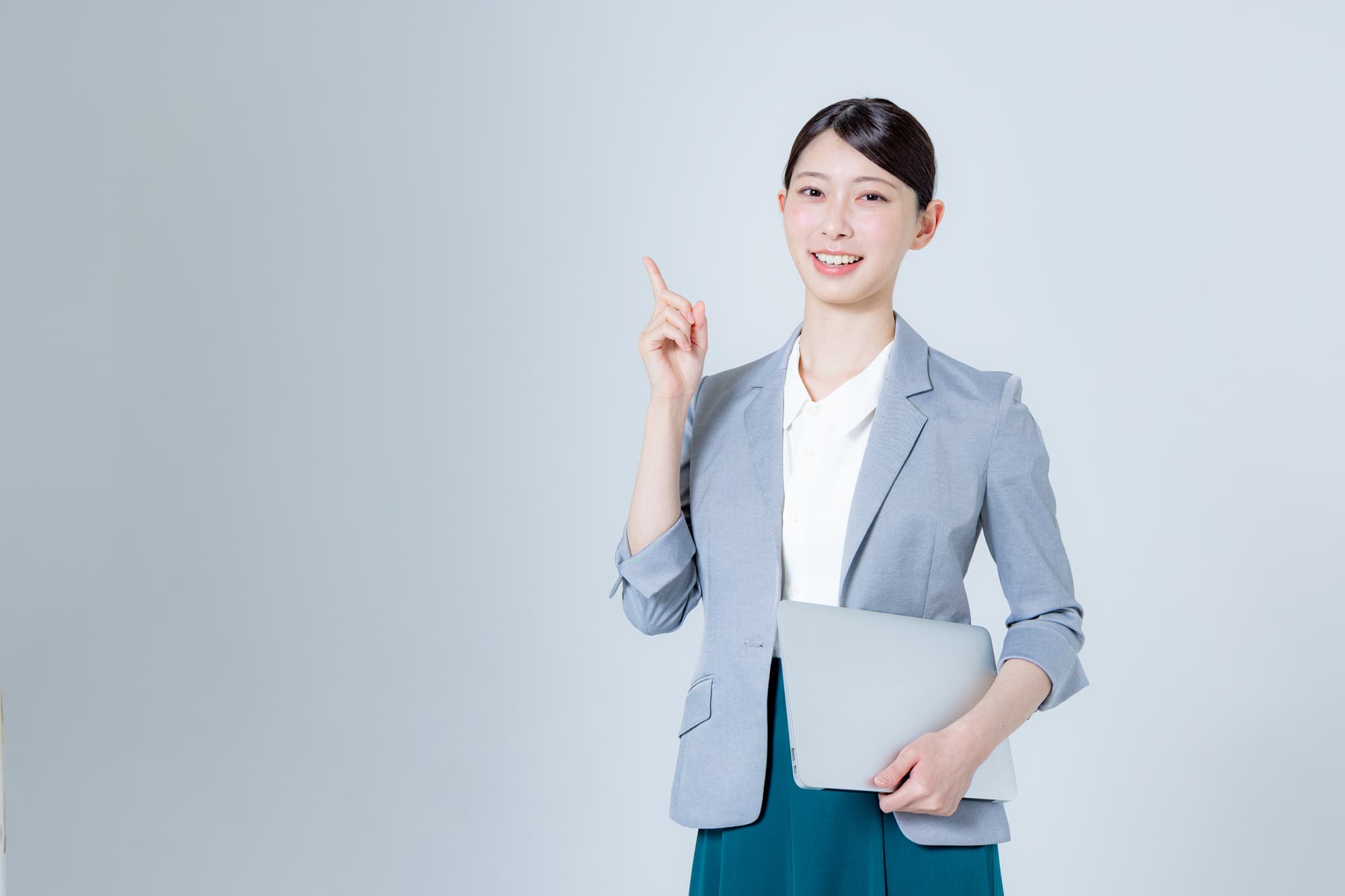 ノートパソコンを片手で持ち、案内をする女性
