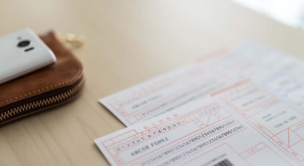 デスク上に置いてあるスマホ・財布・払込取扱票