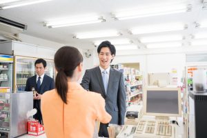 コンビニのレジで会計をする男性
