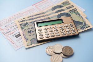 払込取扱票と現金、電卓