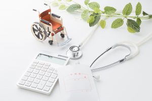 電卓と聴診器、外用薬、車椅子のミニチュア