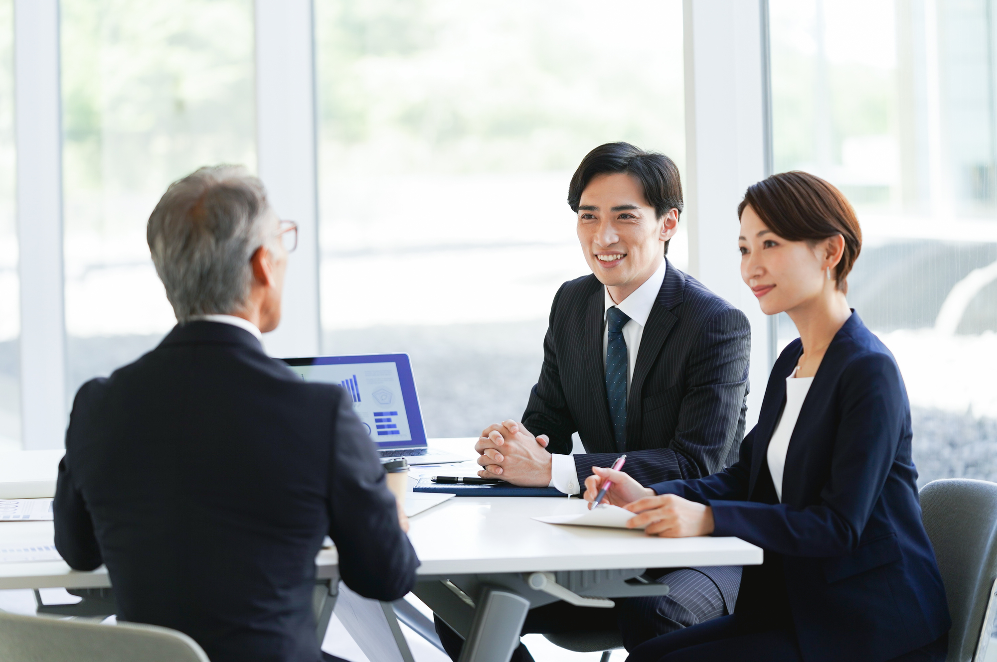 商談をする3人のビジネスパーソン