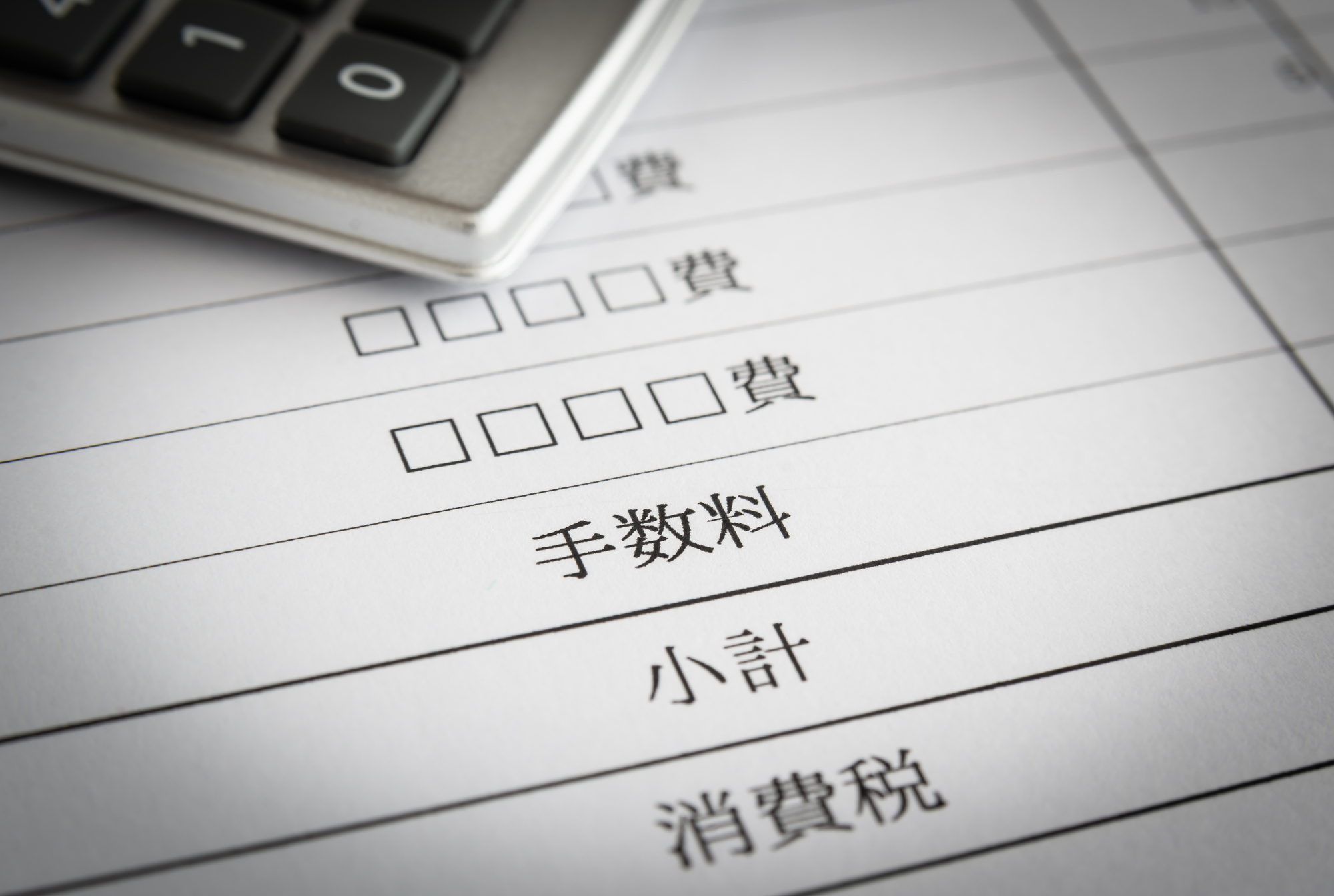 手数料などの内訳が書かれた紙と電卓