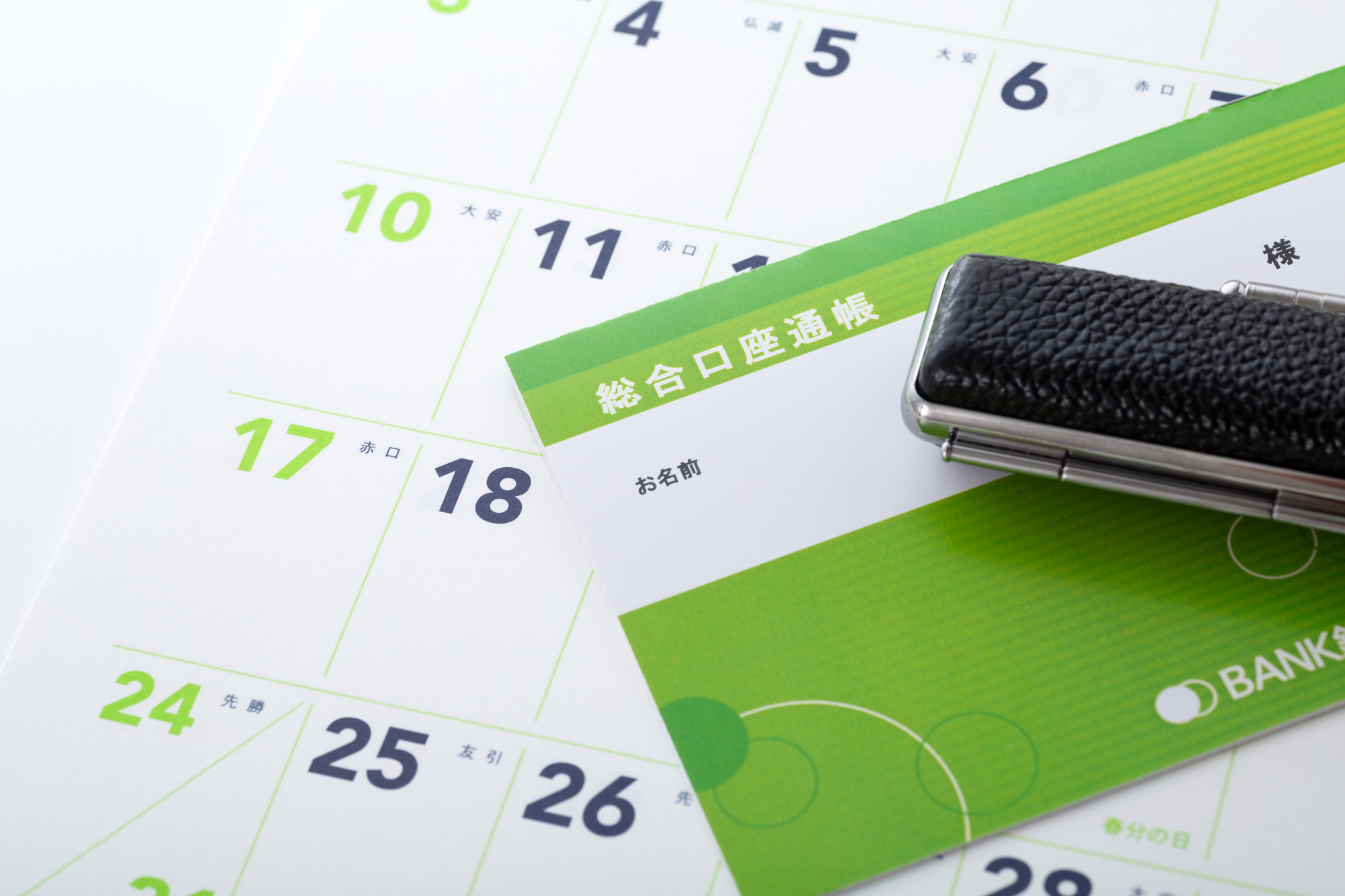 カレンダーの上に置かれた通帳と印鑑