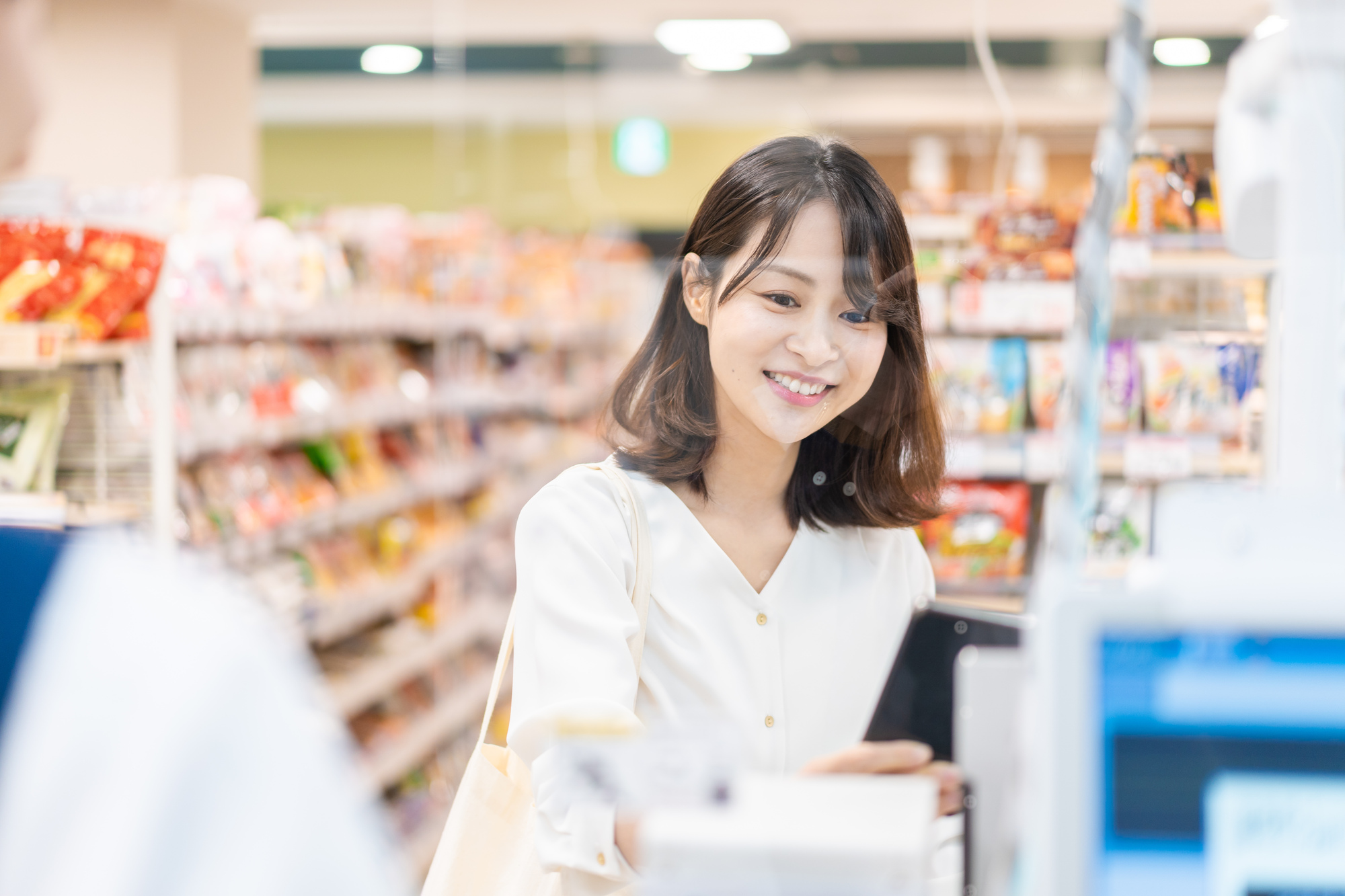 コンビニで支払いを行う女性