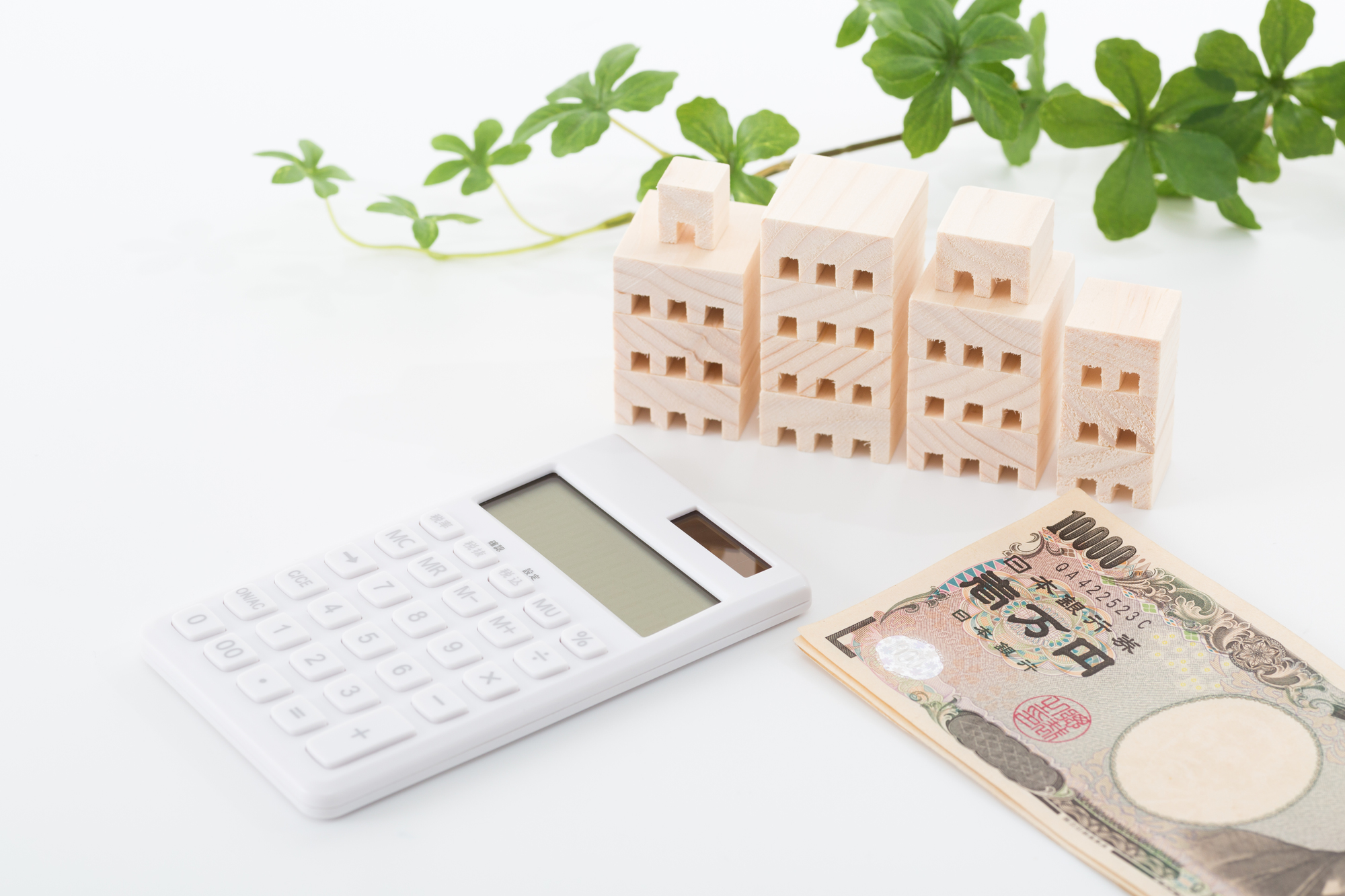 マンションの模型と電卓、紙幣