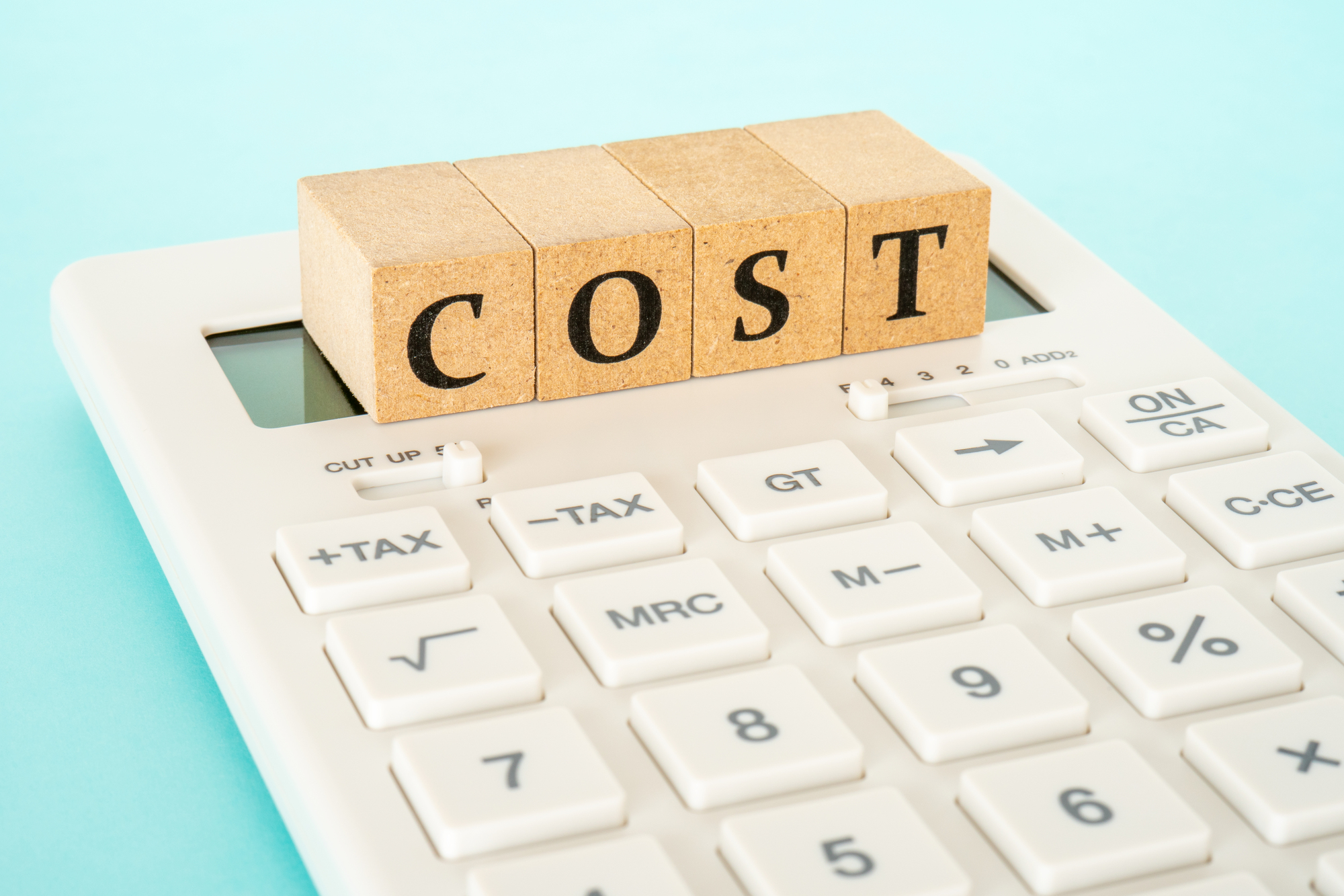 電卓の上に乗った「COST」のブロック