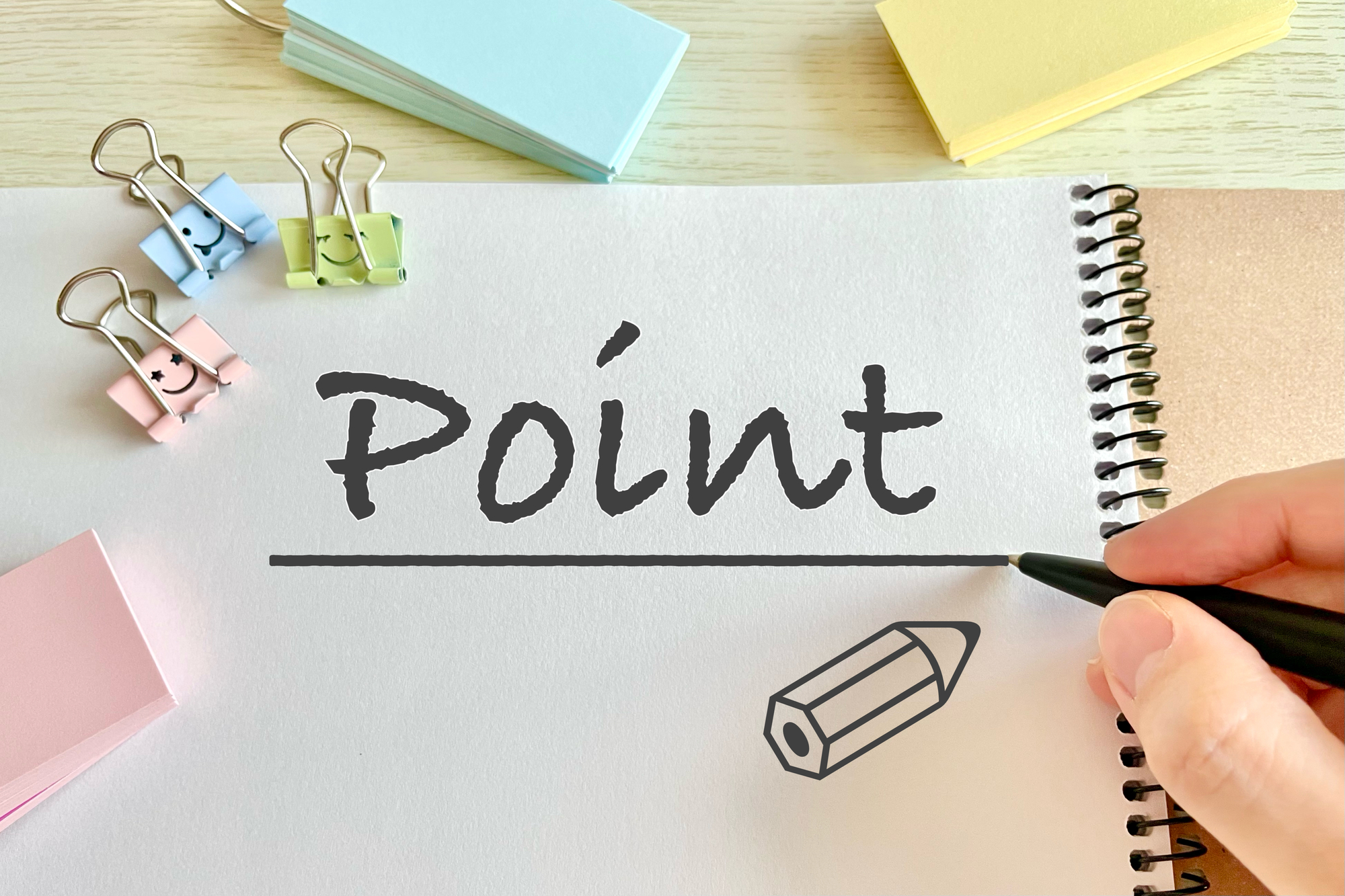 POINTと書かれたノート、ペンを持つ手、クリップ