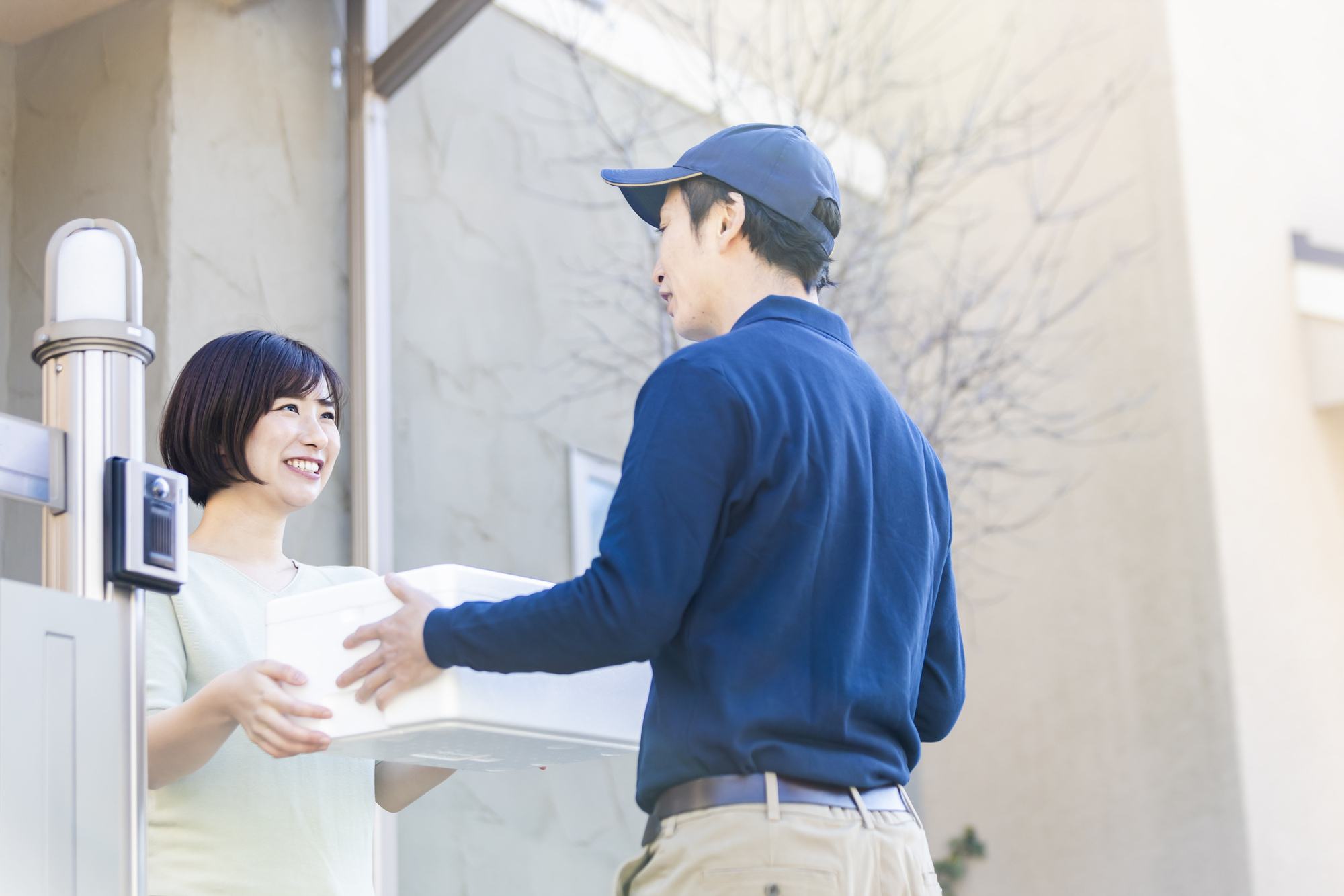 荷物を手渡す配達員と受け取る女性