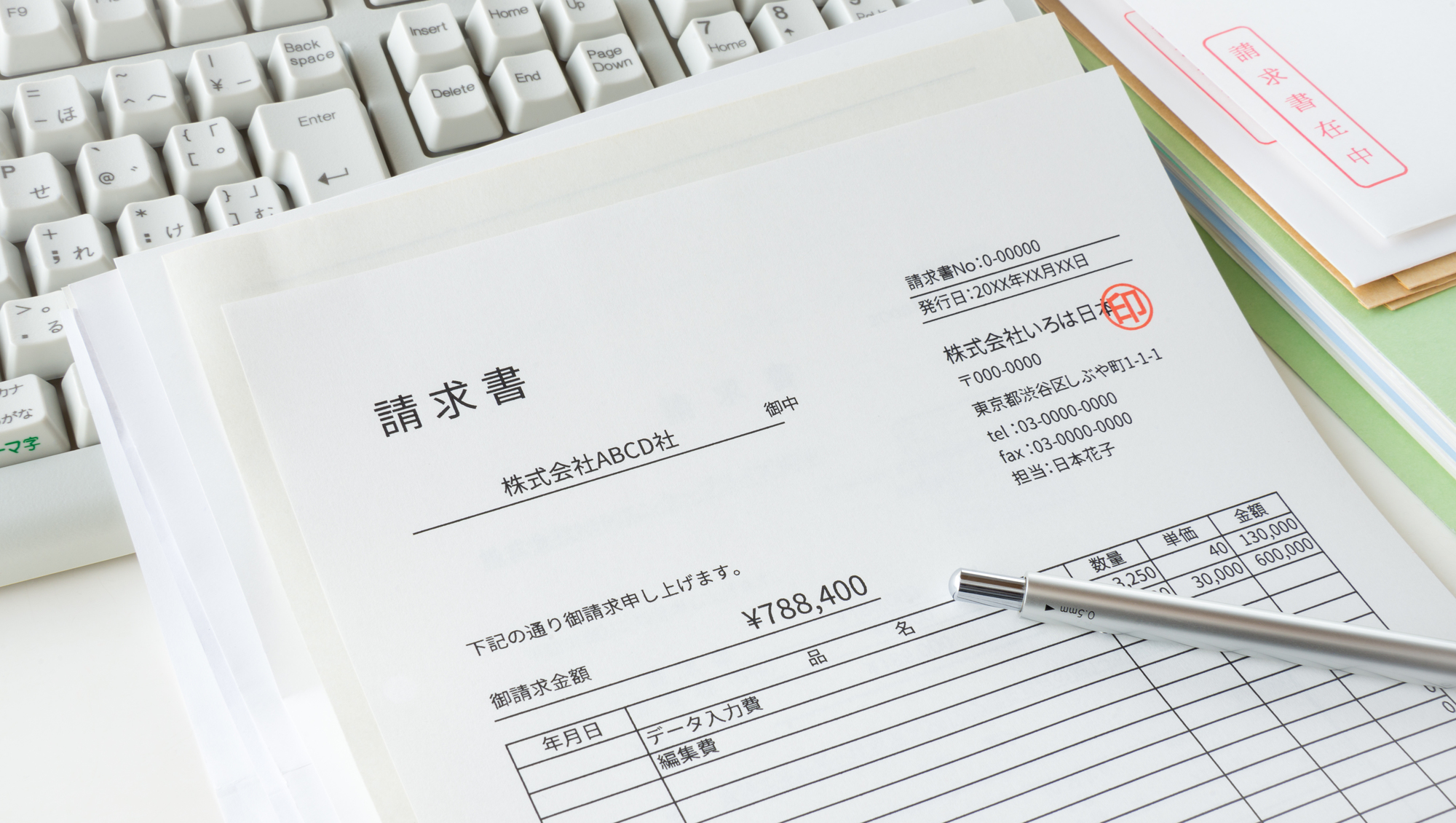 キーボードの上に置かれた請求書