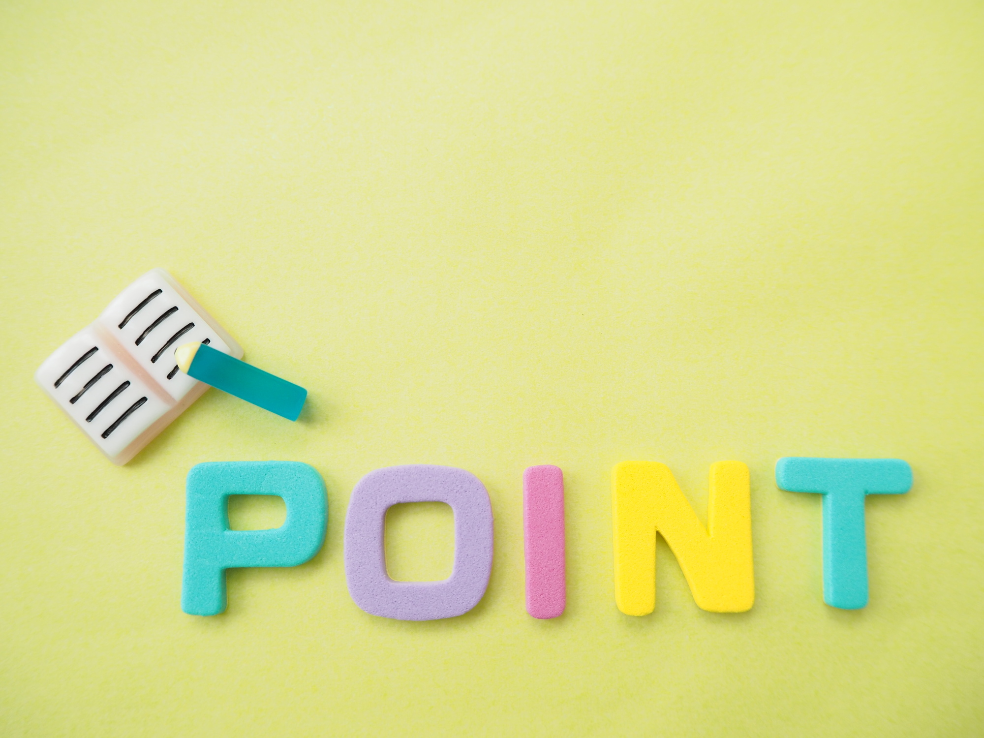 カラフルな「POINT」の文字と、ミニチュアのノート