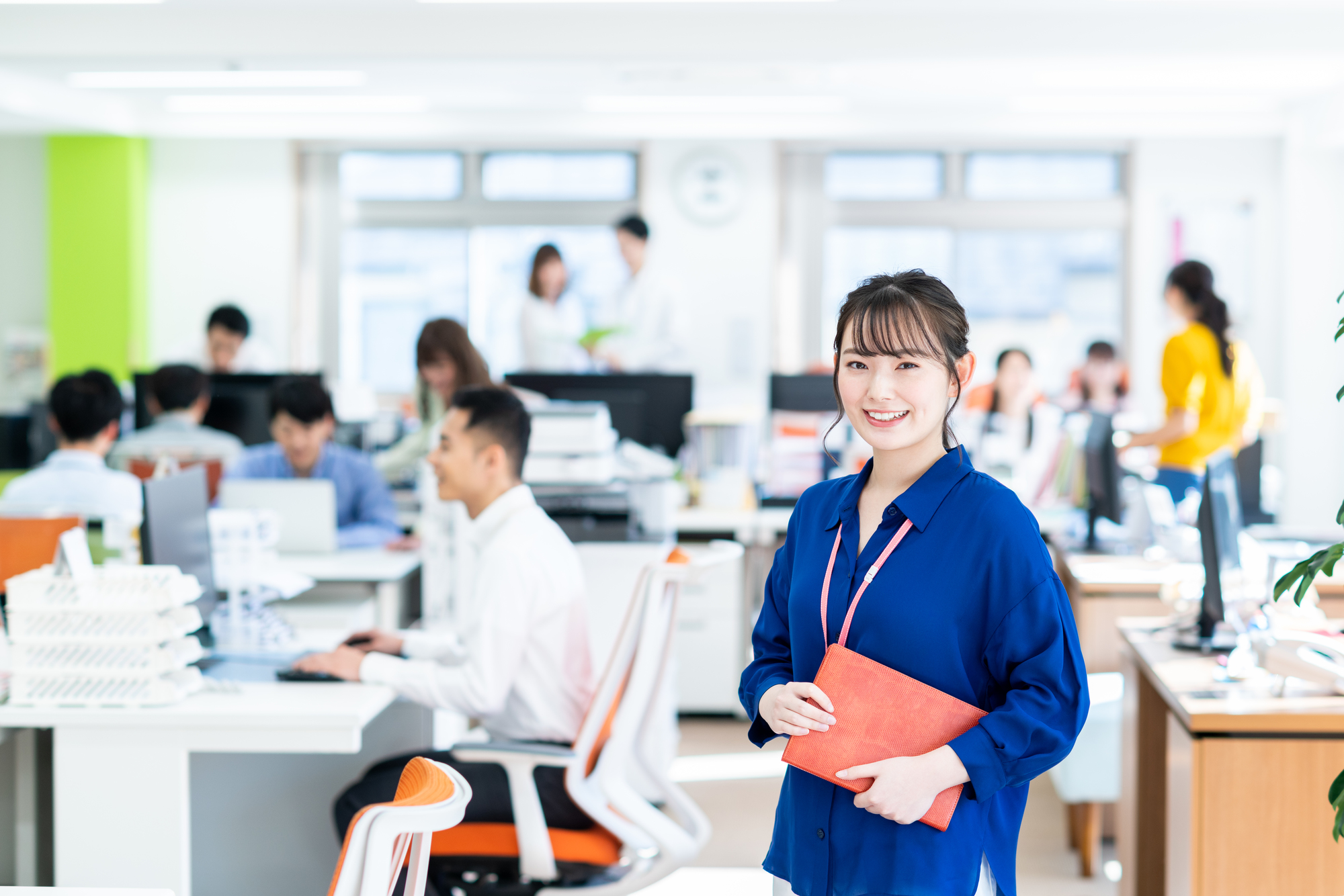 オフィスで書類を持つ笑顔の女性