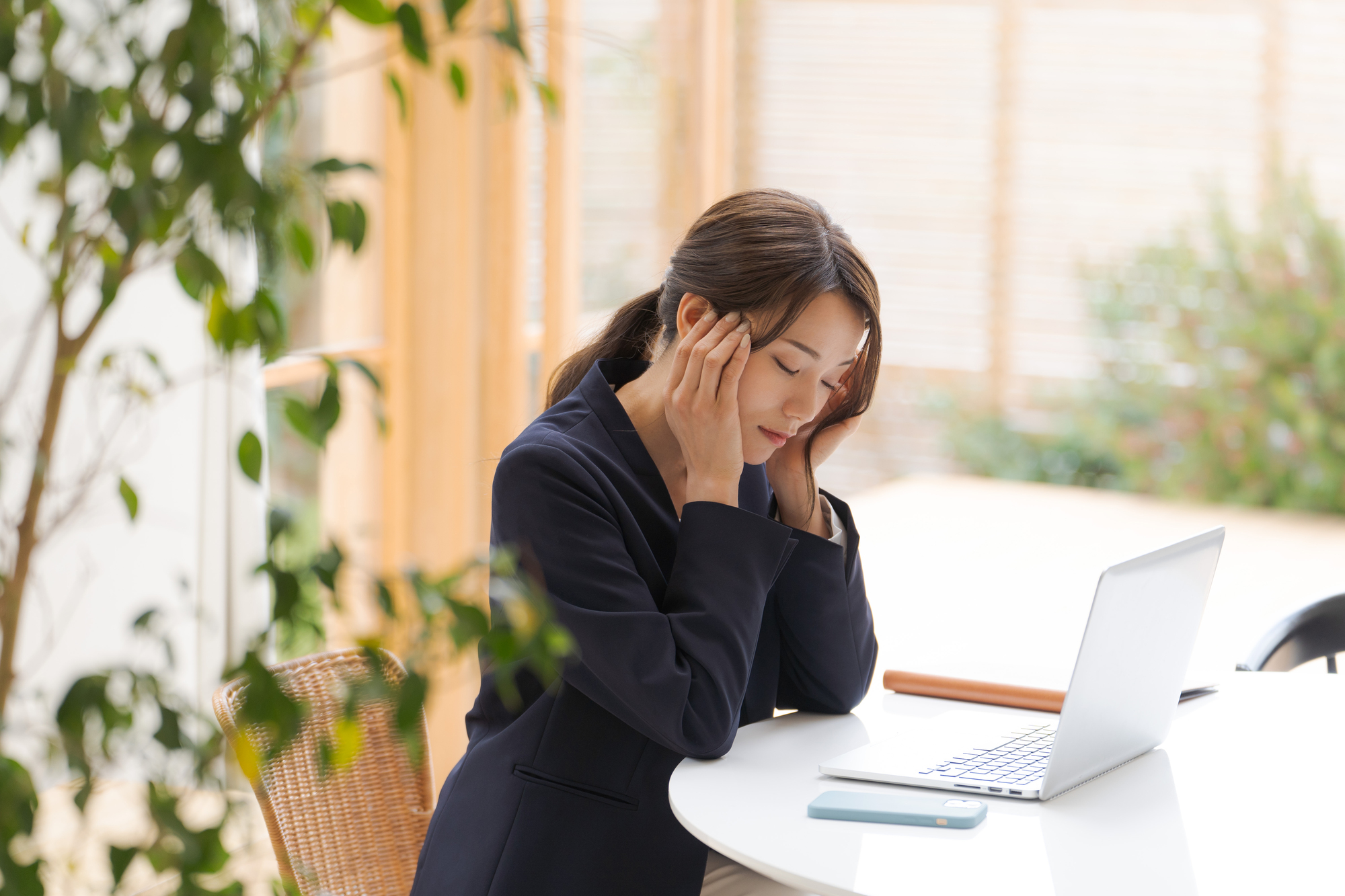 PCの前で悩んでいるひとりの女性