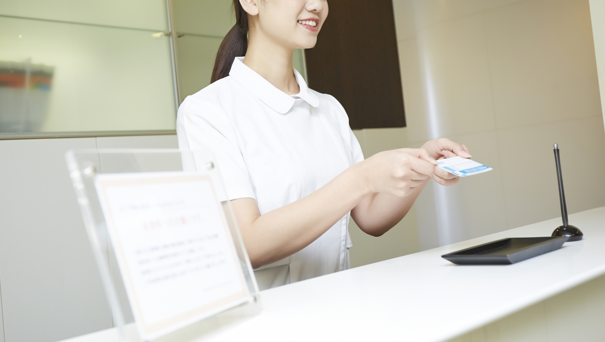 会計窓口でカードを手に持っている女性