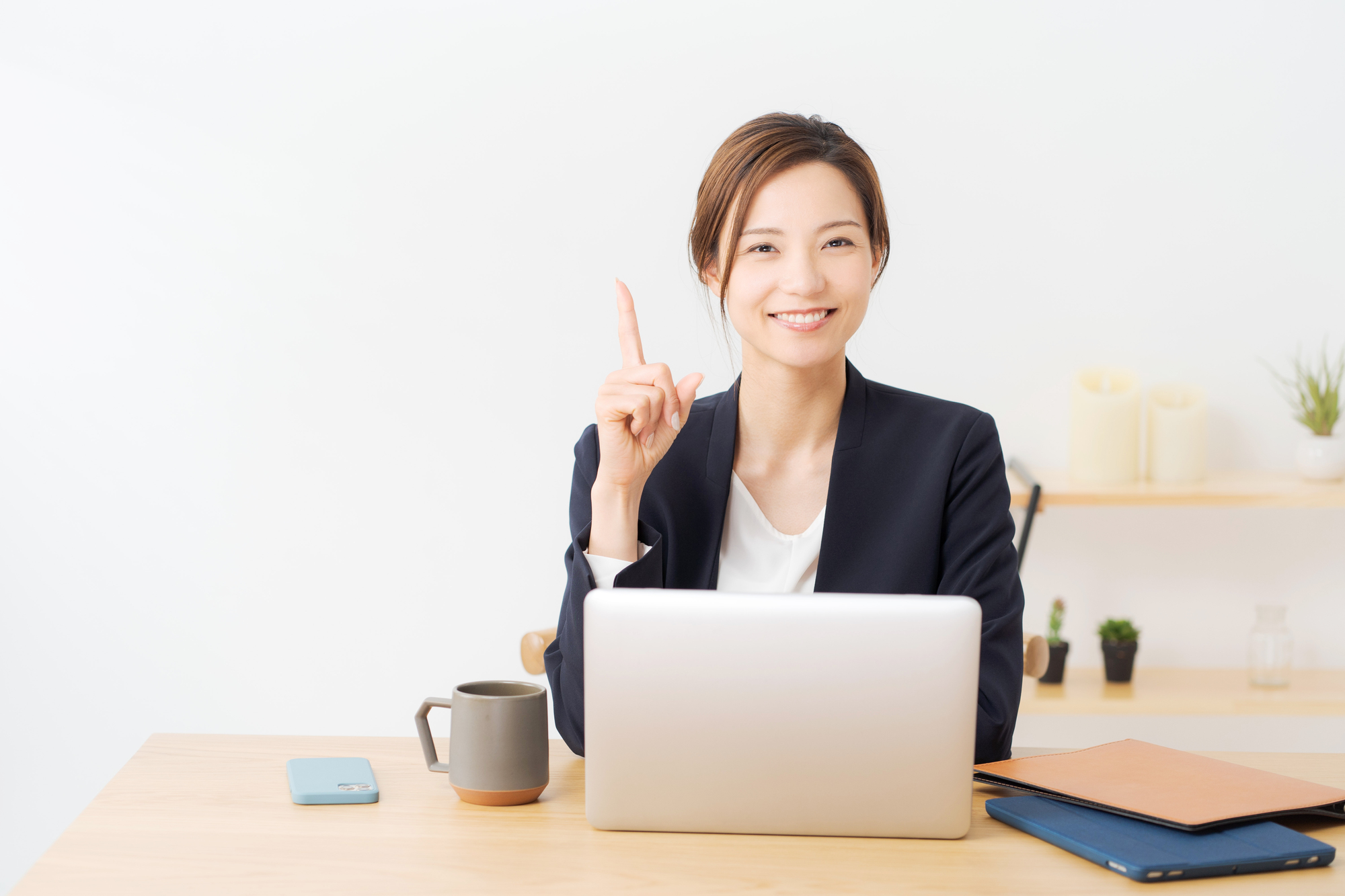 人さし指を立てて、笑顔を浮かべる女性