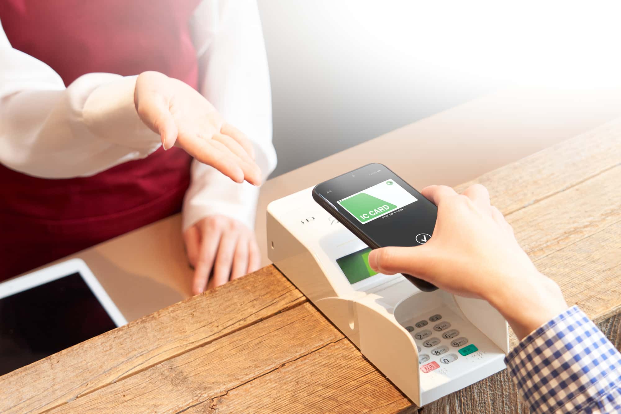 リーダーに電子マネーをかざしている人