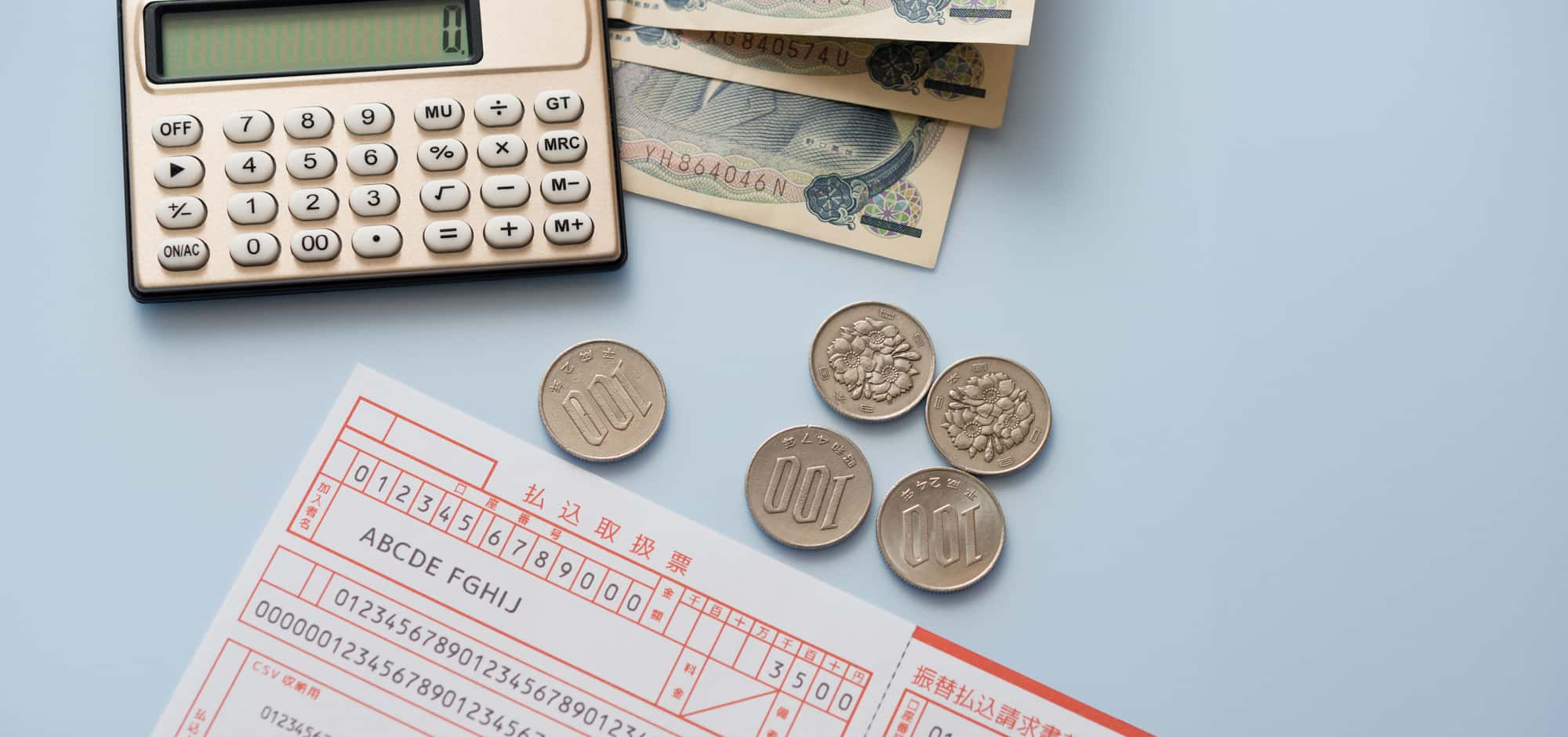 必要事項が記載された払込票と電卓、現金