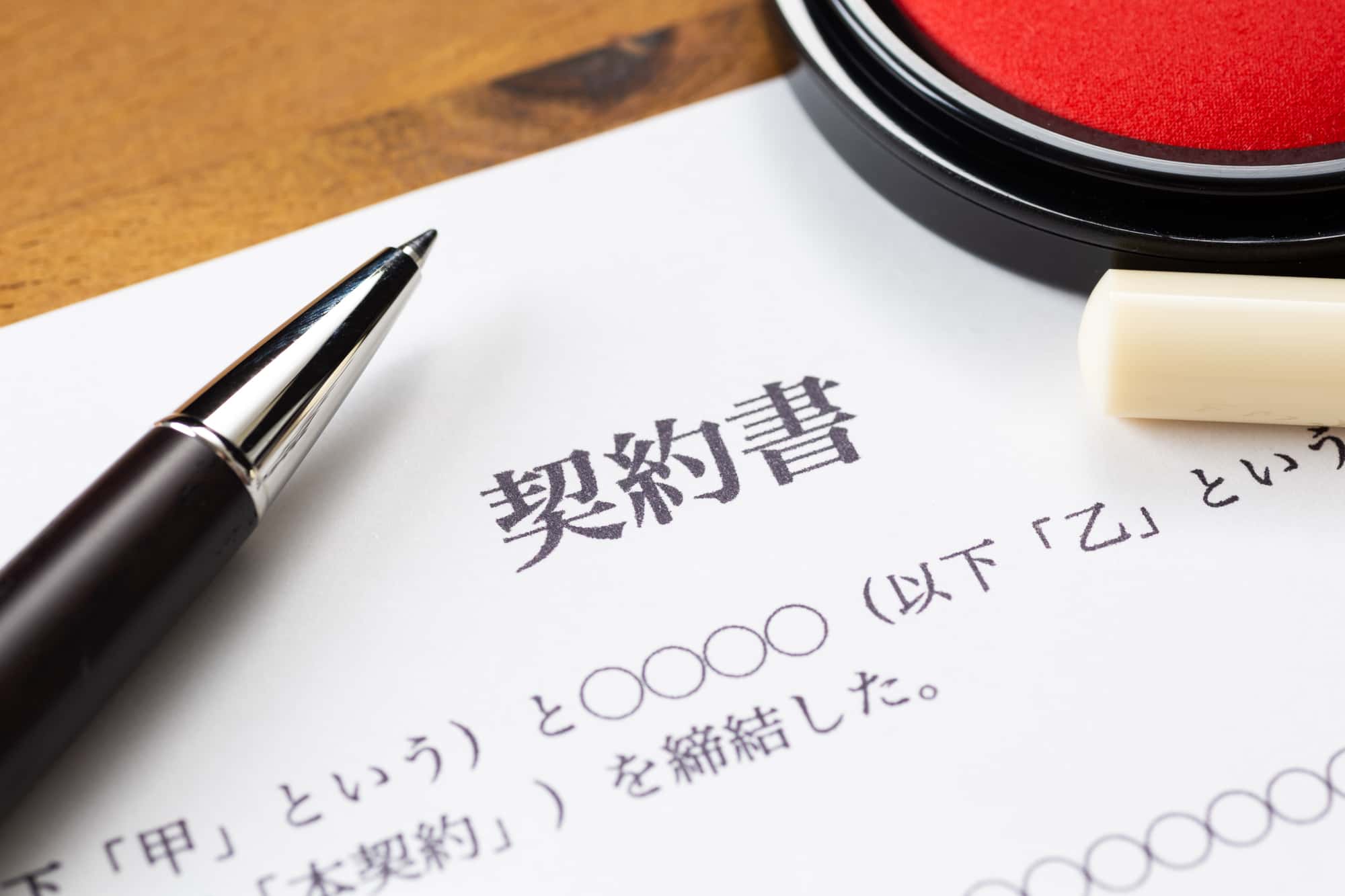 机の上に置いてある契約書とボールペン