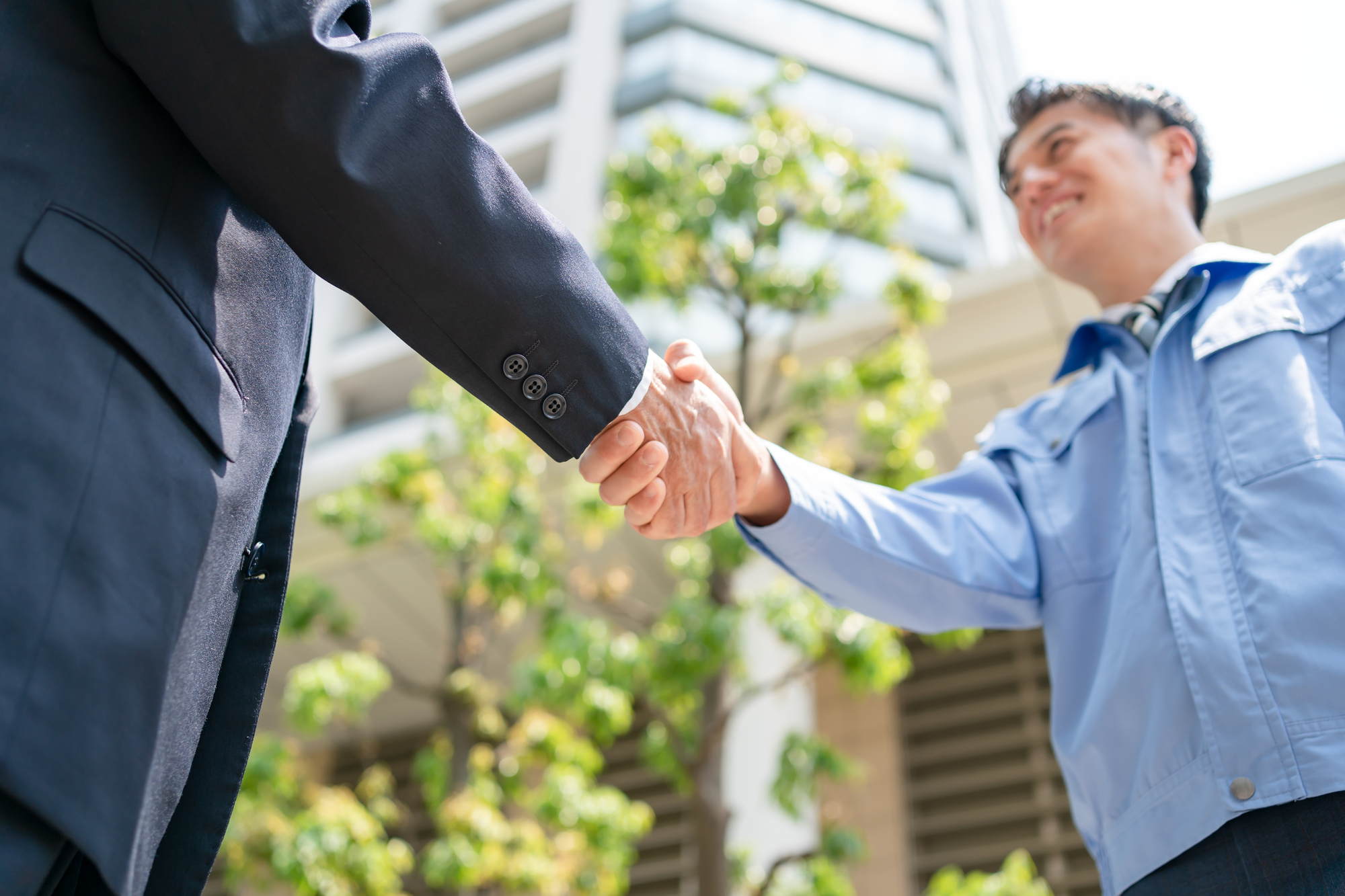 建物の前で握手をする2人の男性