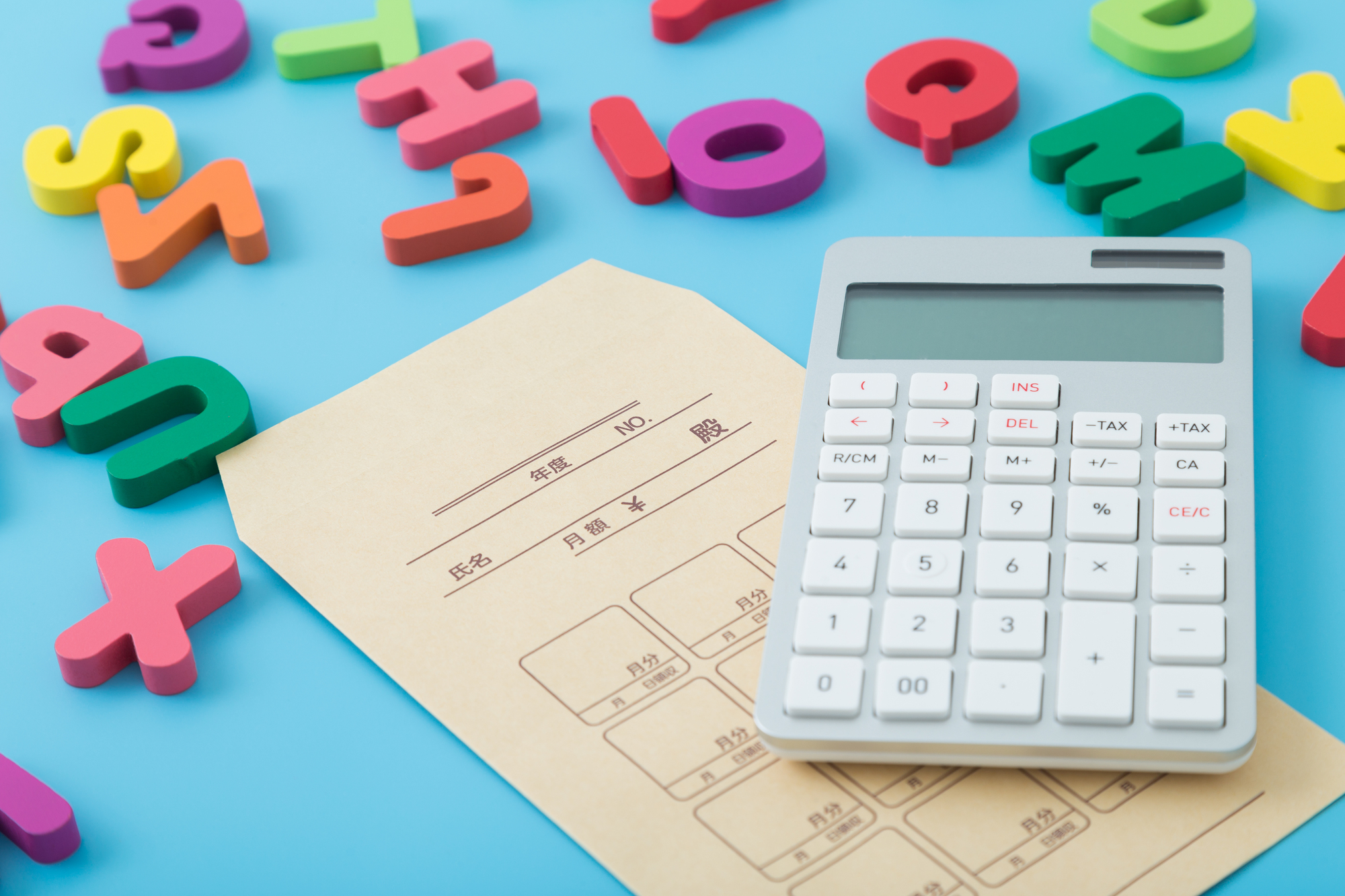 集金袋と電卓、アルファベットの模型