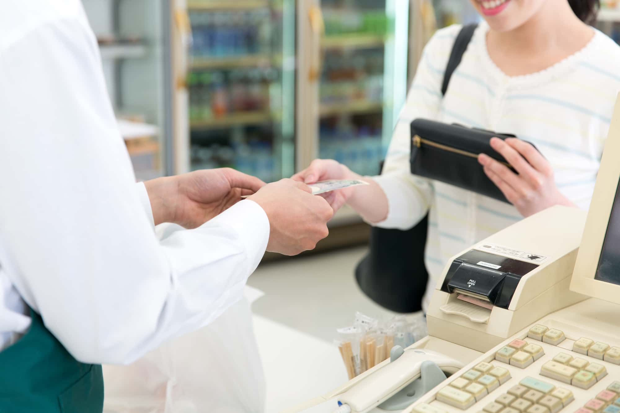 コンビニのレジで代金を支払う人