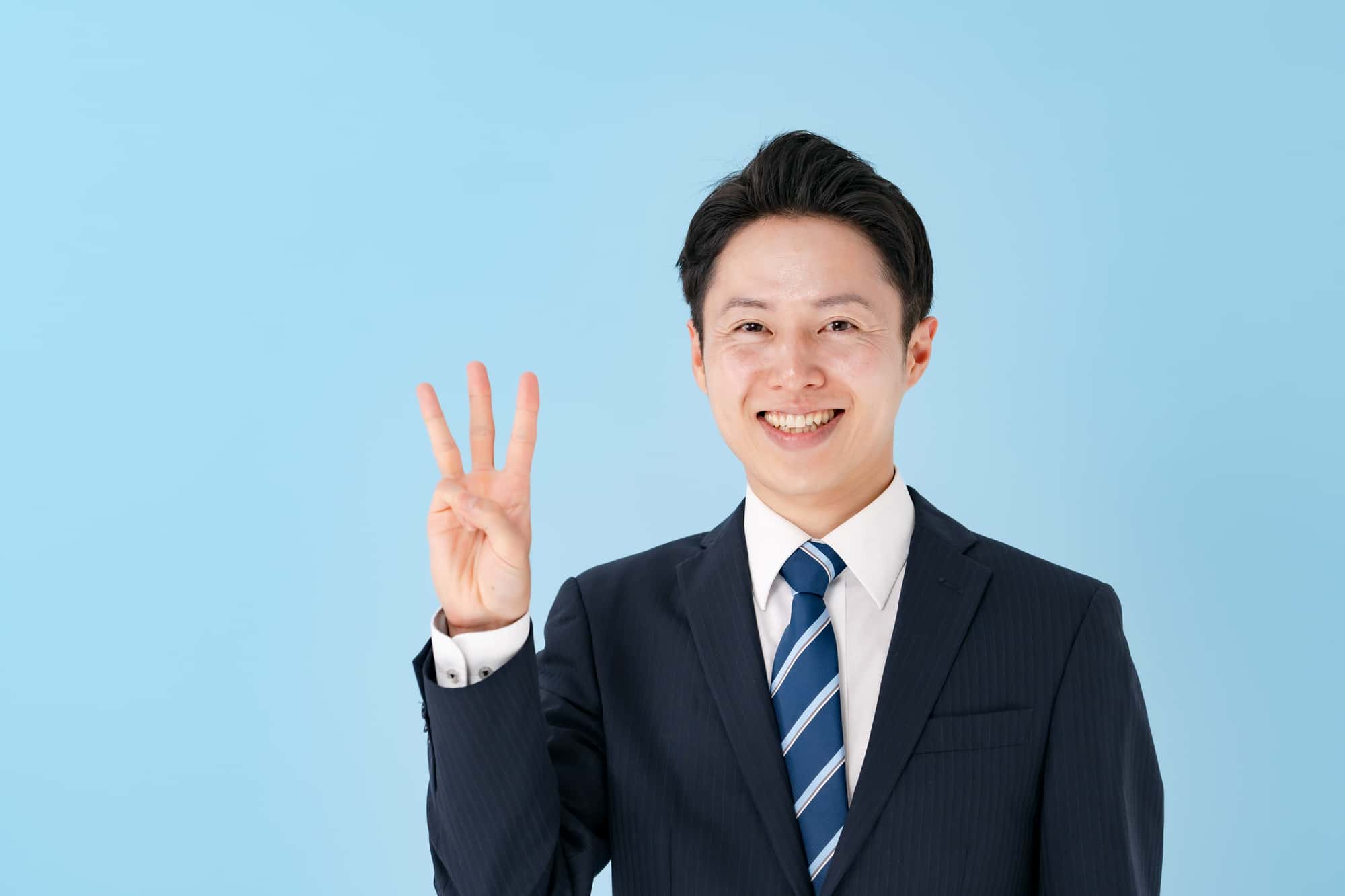 指で「3」を示す笑顔のビジネスパーソン