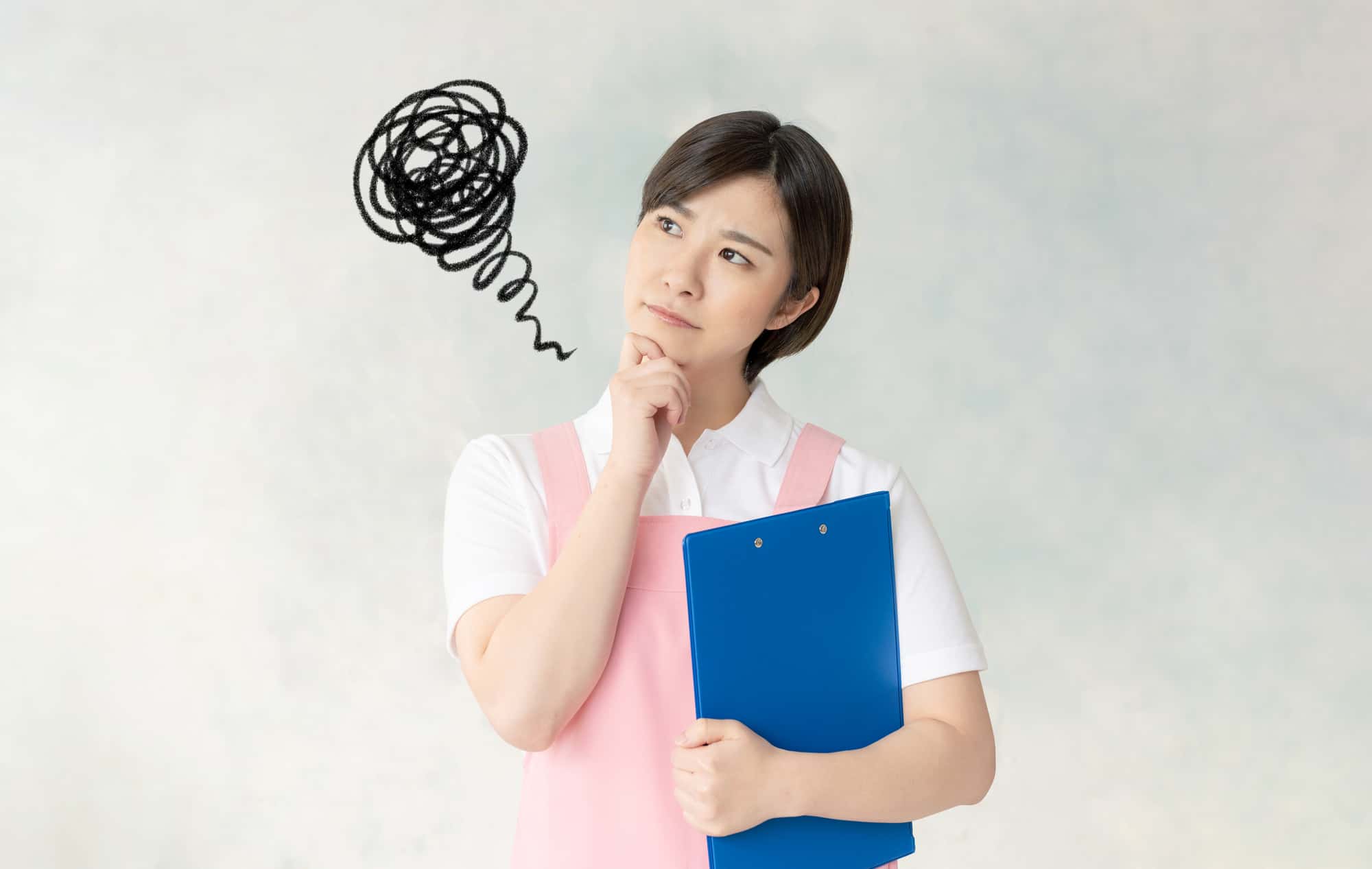 ファイルを片手に持ち、疑問を浮かべる保育士