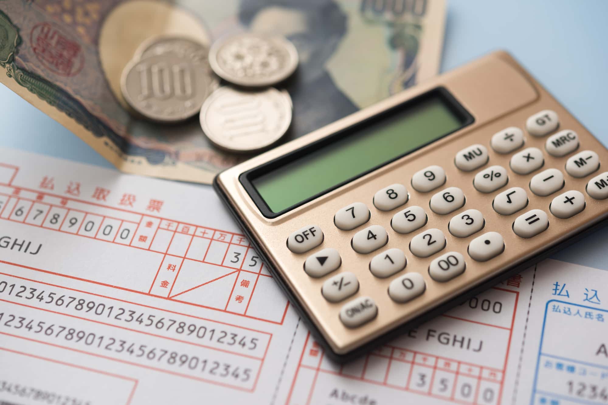 払込票と紙硬貨、電卓