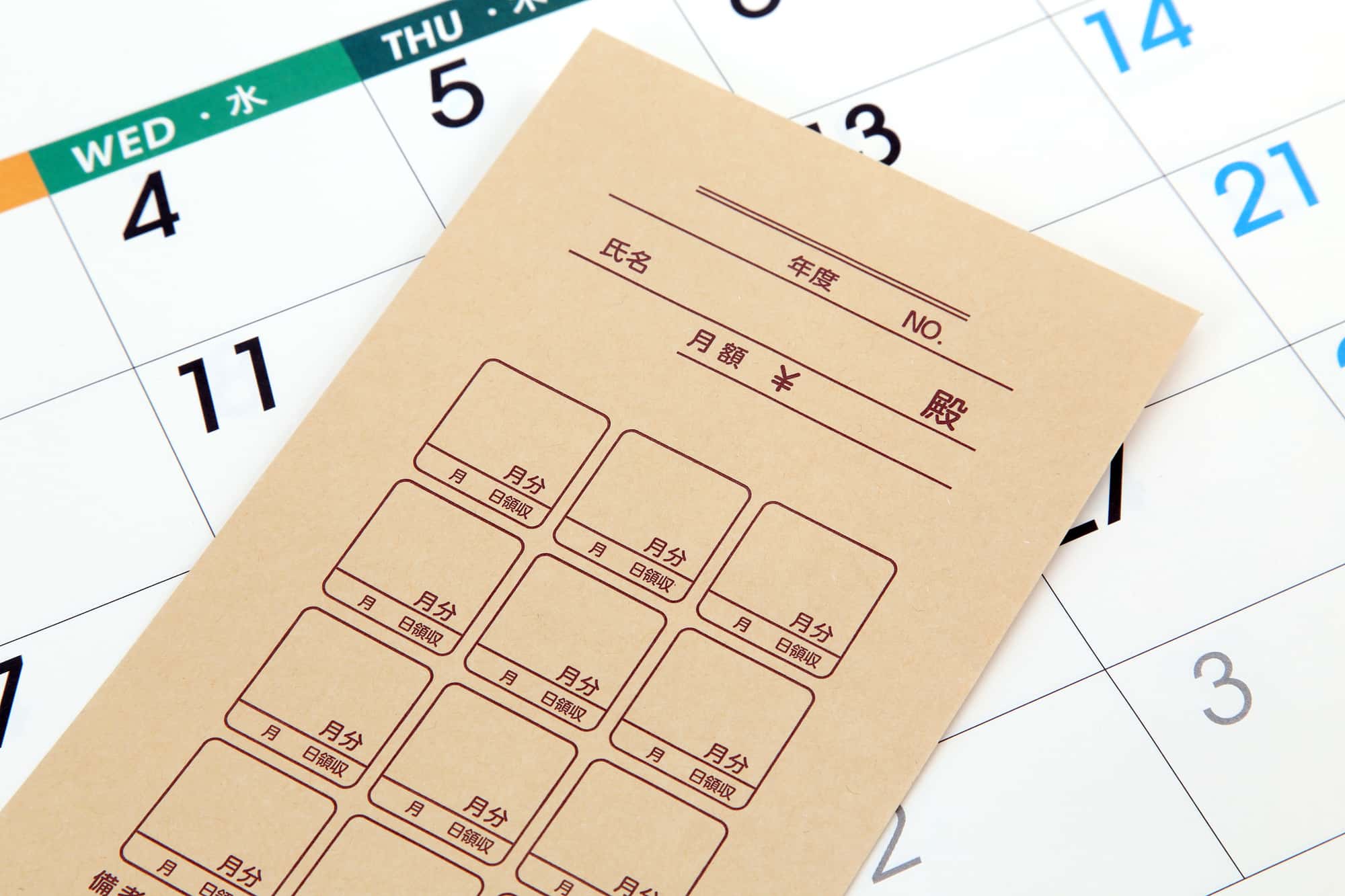 カレンダーの上に置かれた集金袋