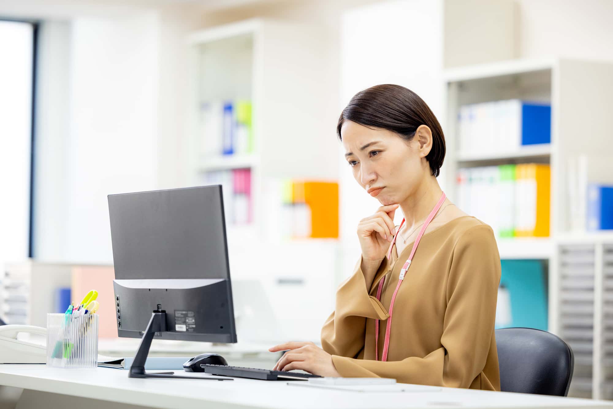 パソコンの画面を見ながら悩む女性