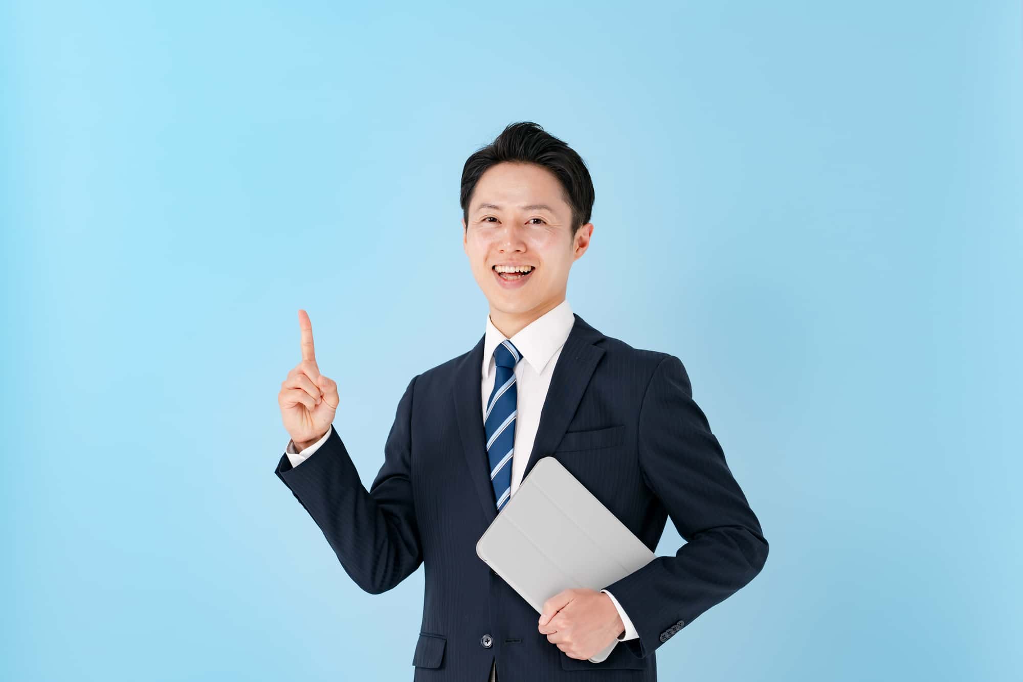 人さし指を上に向け、笑顔を浮かべるビジネスパーソン