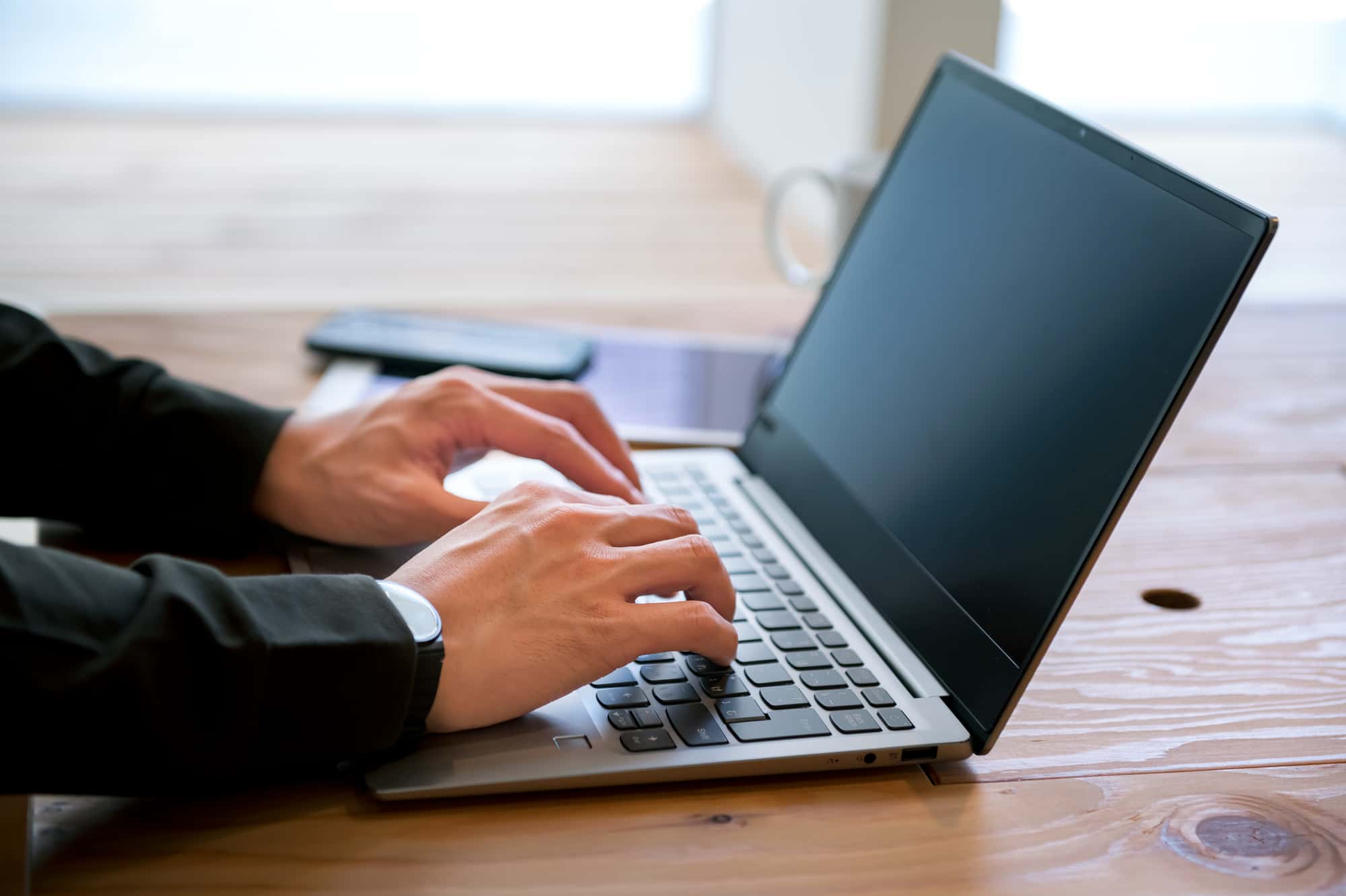 ノートパソコンを操作している人の手元