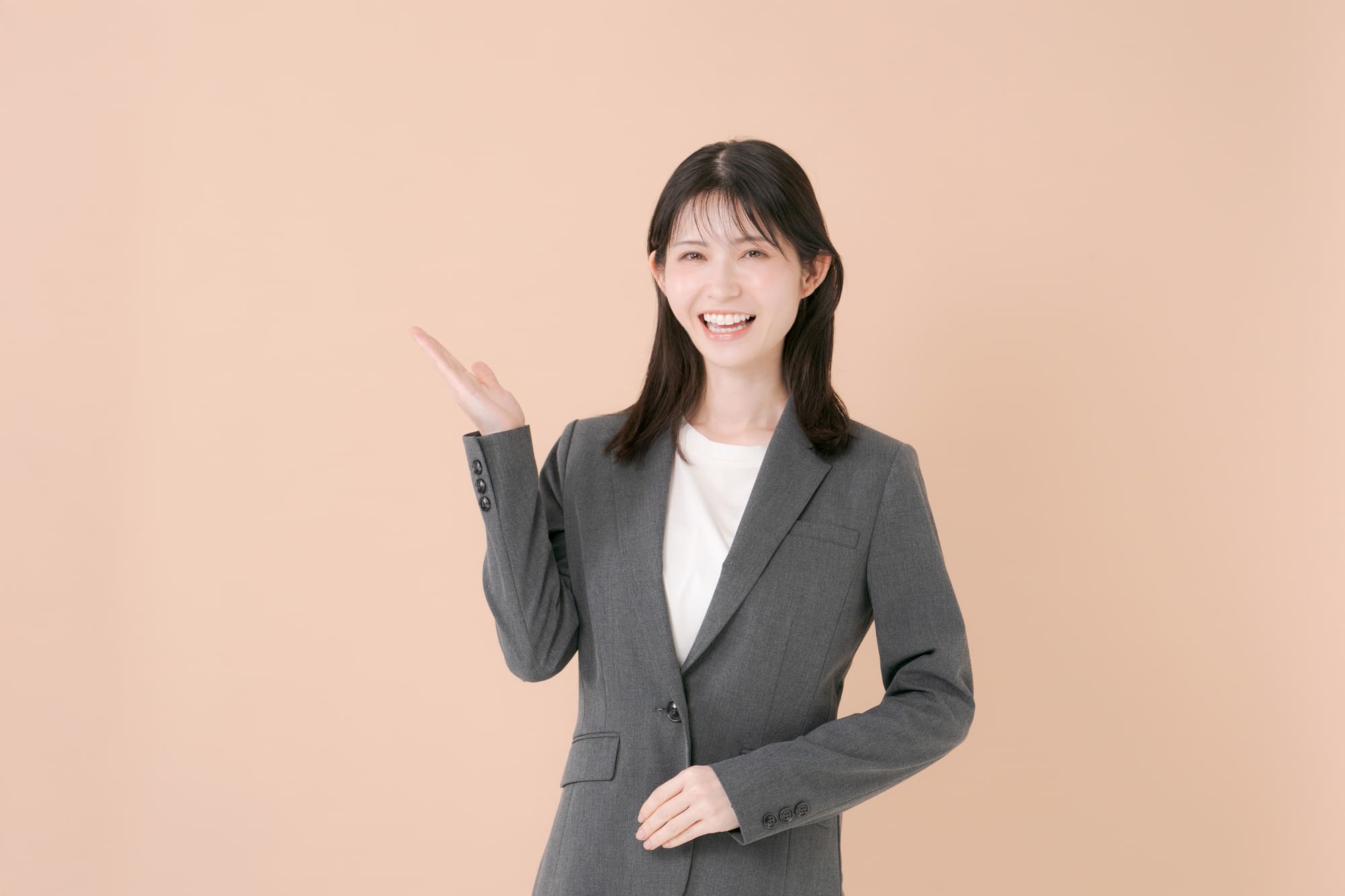 笑顔で案内をするスーツ姿の女性