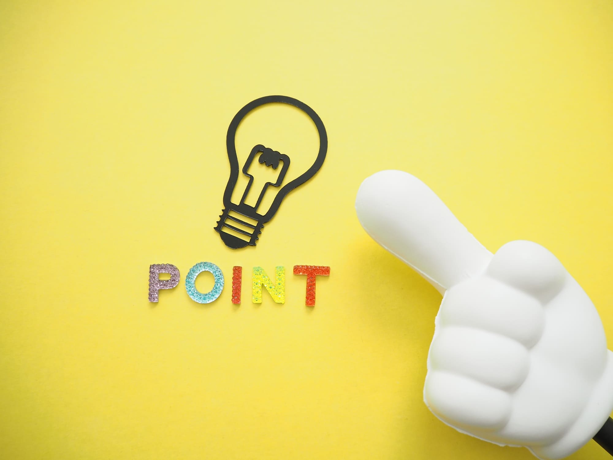 カラフルな「POINT」の文字と電球マーク、指さし棒