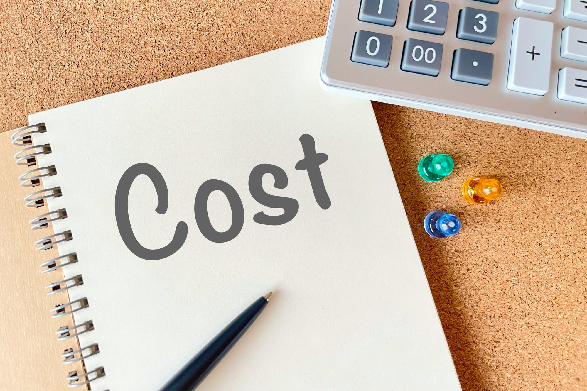 「Cost」と書かれたノートとペン、電卓