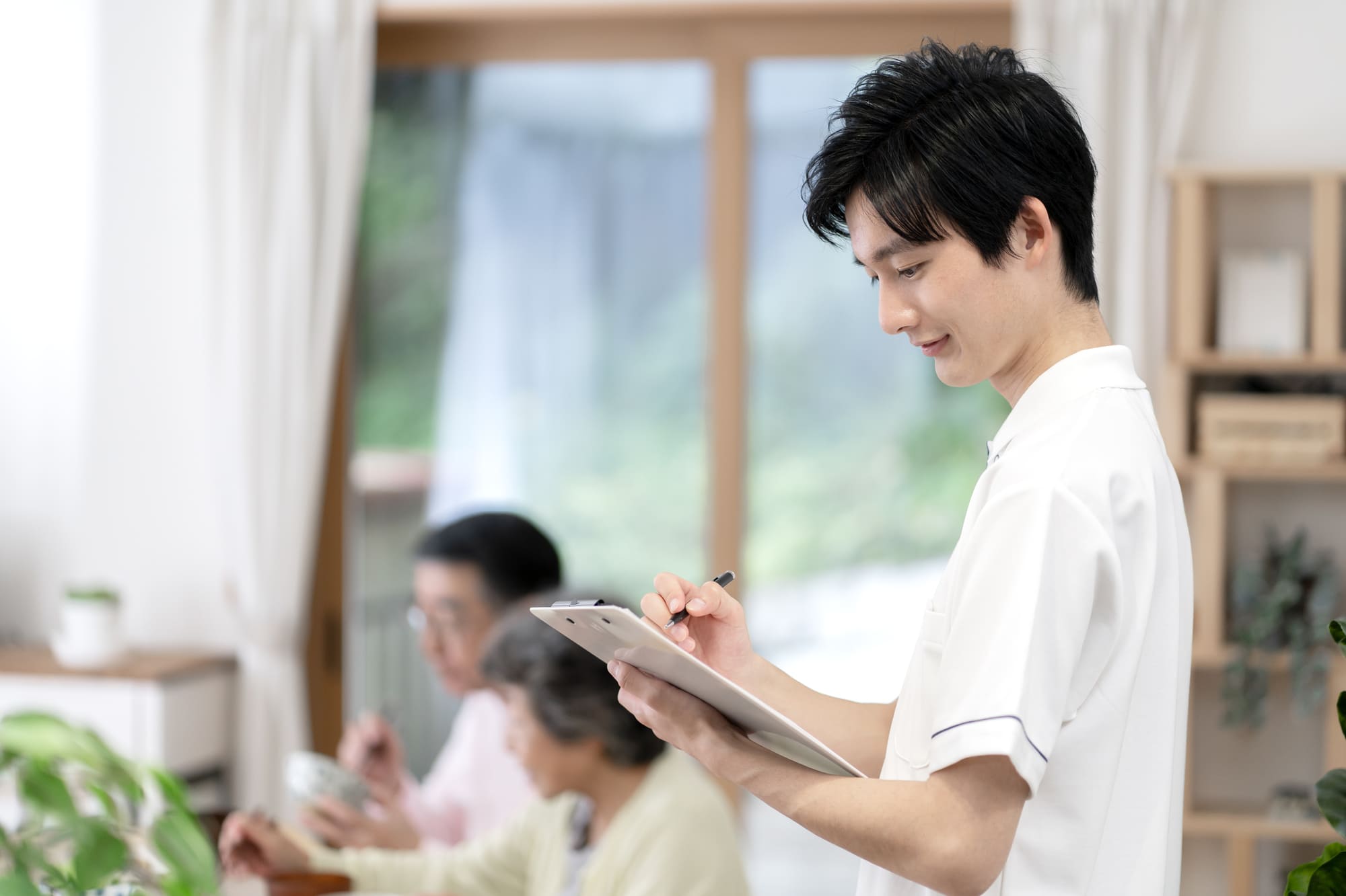 バインダーを使ってメモをとる介護スタッフ