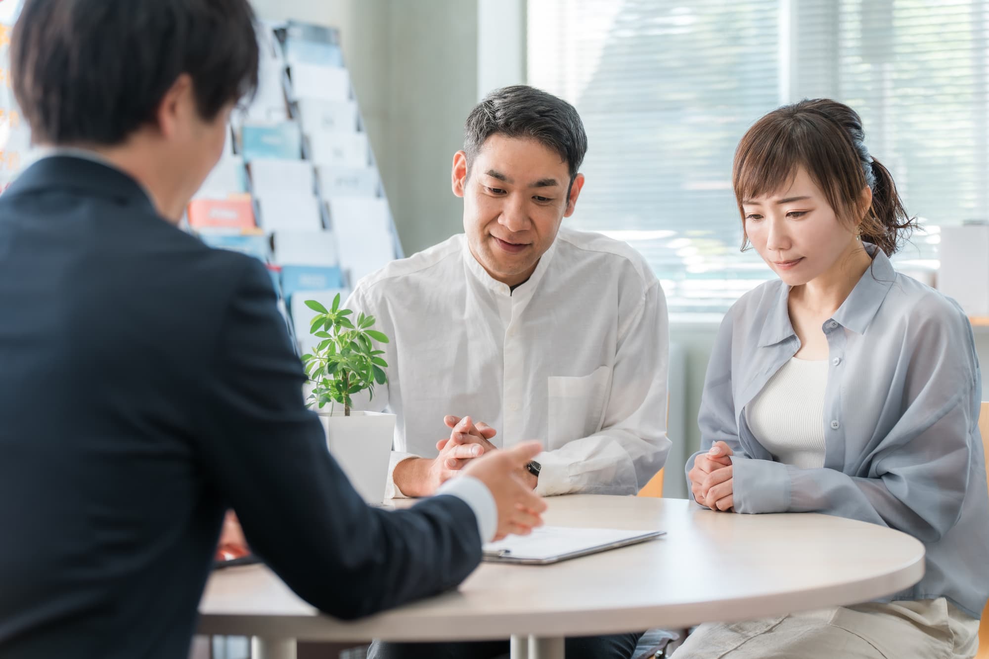 夫婦に向けて説明をする旅行会社の男性