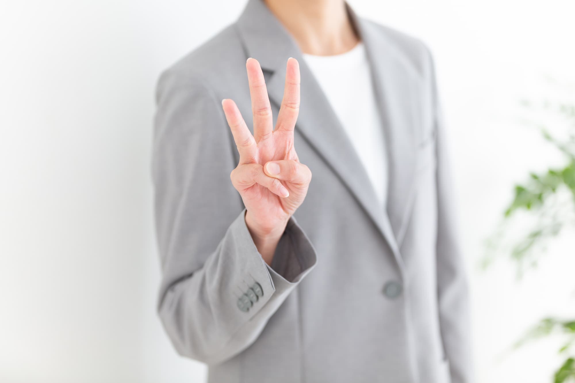 指で「3」を示すビジネスパーソン