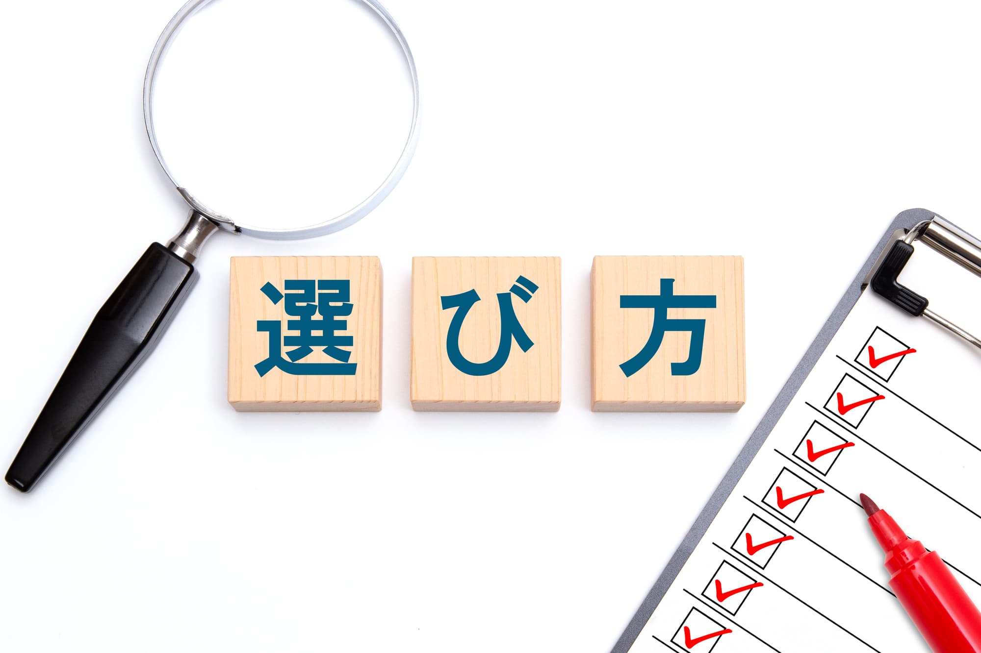 「選び方」と書かれた木のブロックと虫眼鏡、チェックリスト、赤ペン