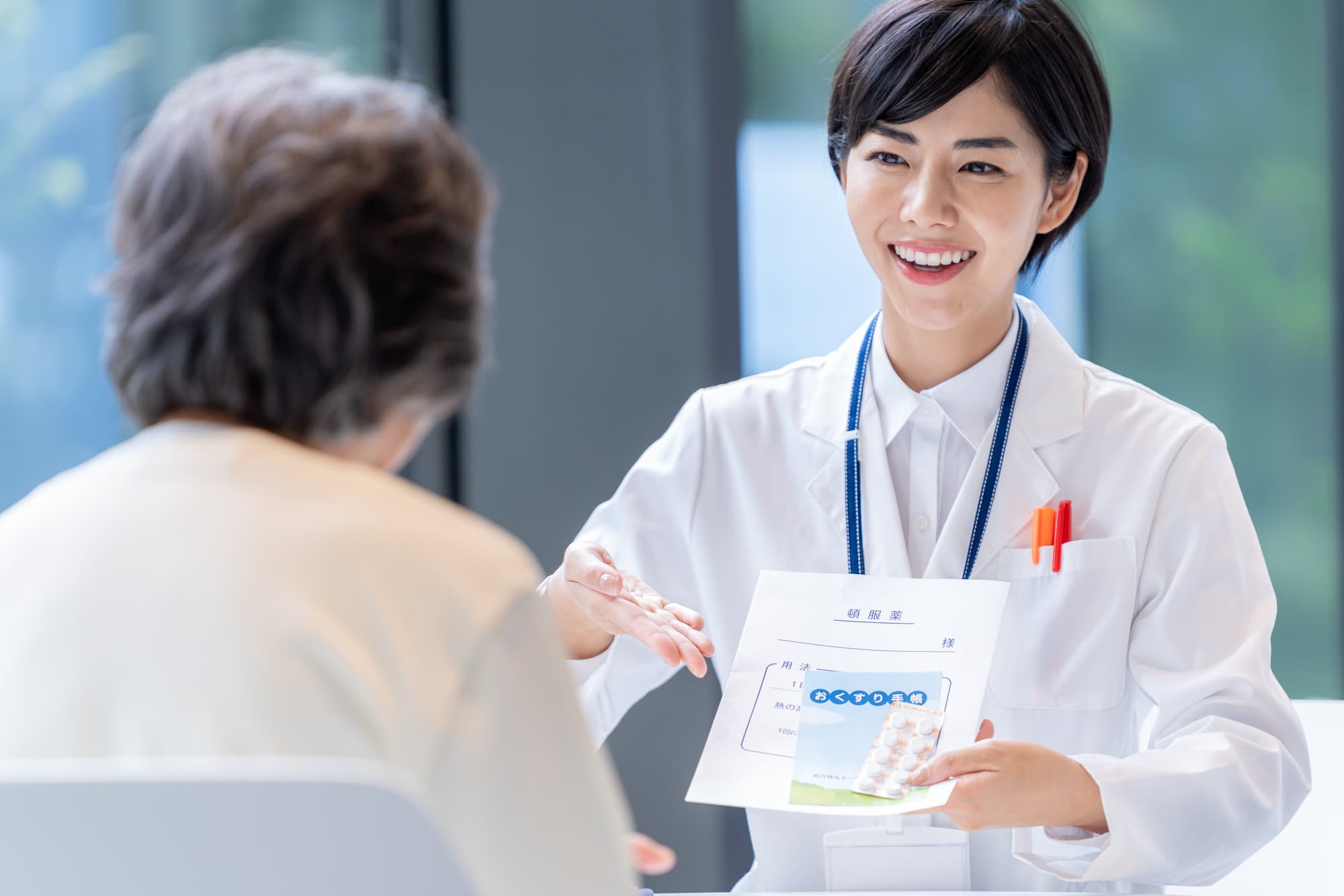 患者に薬を渡している薬剤師