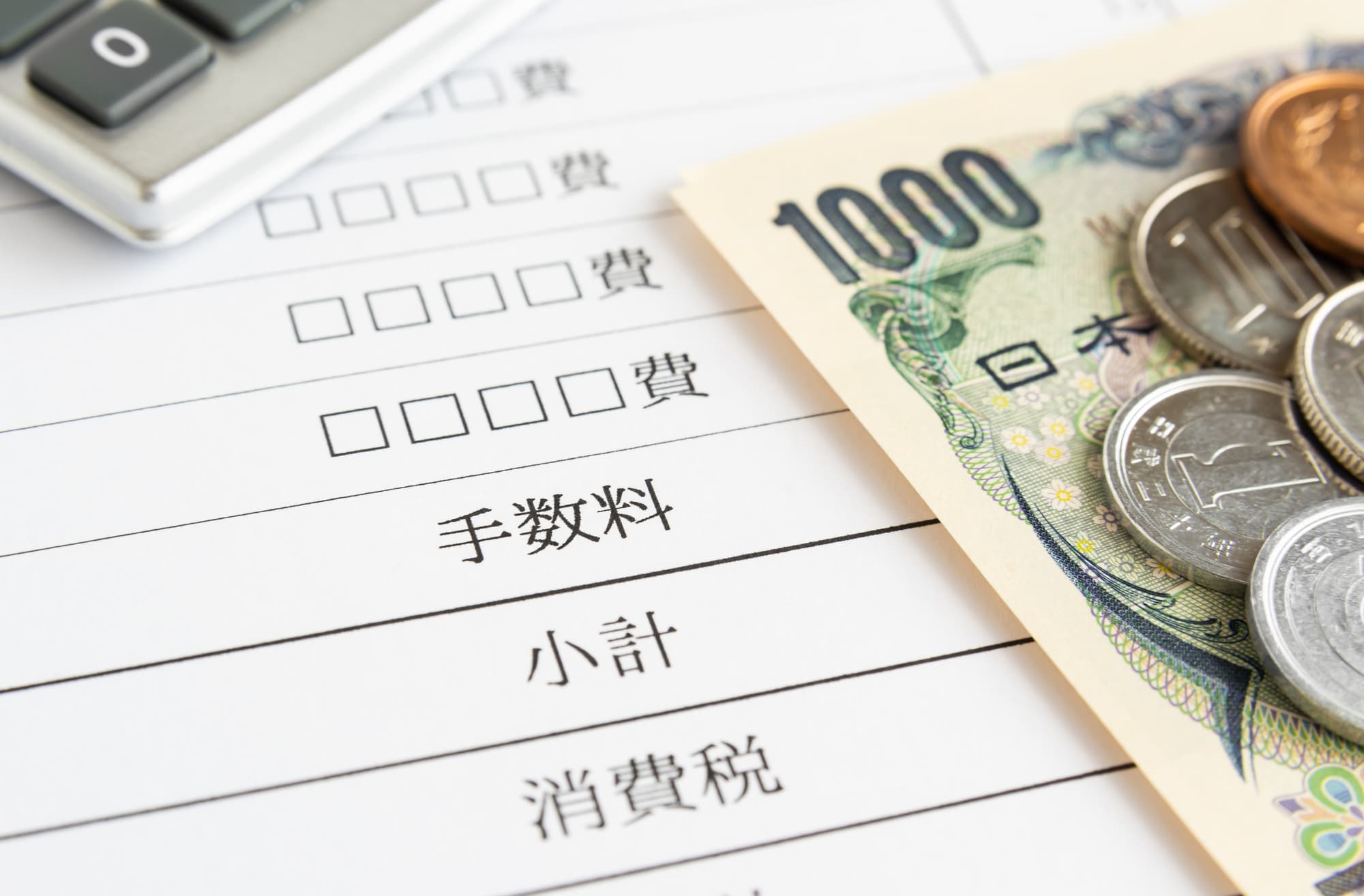 請求書の上に現金と電卓が置いてある