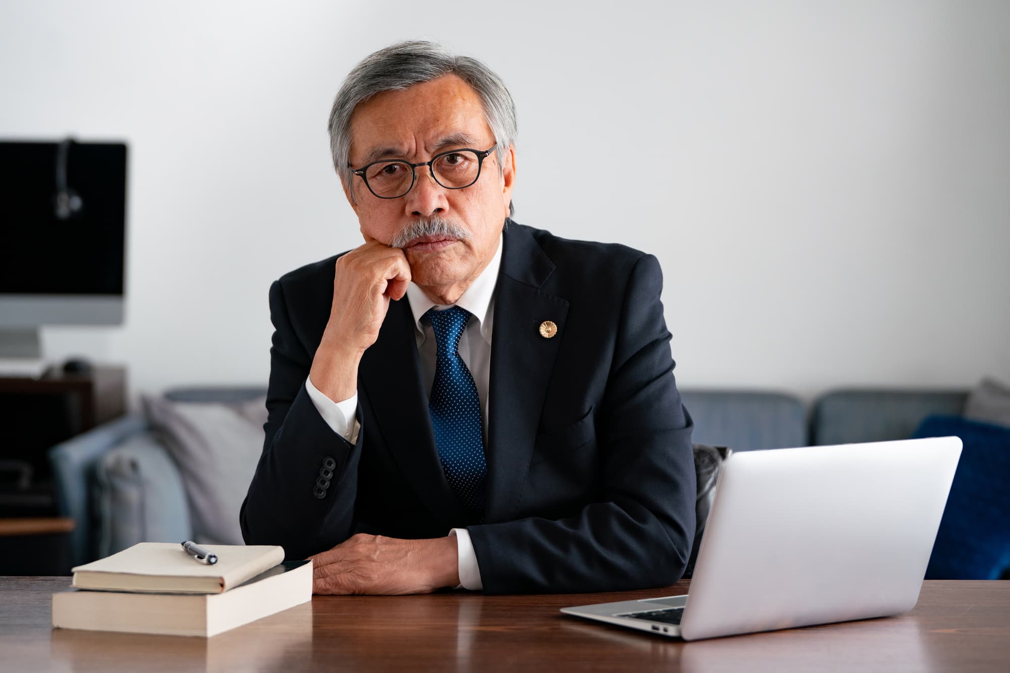 デスクに座り、困った表情を浮かべる弁護士
