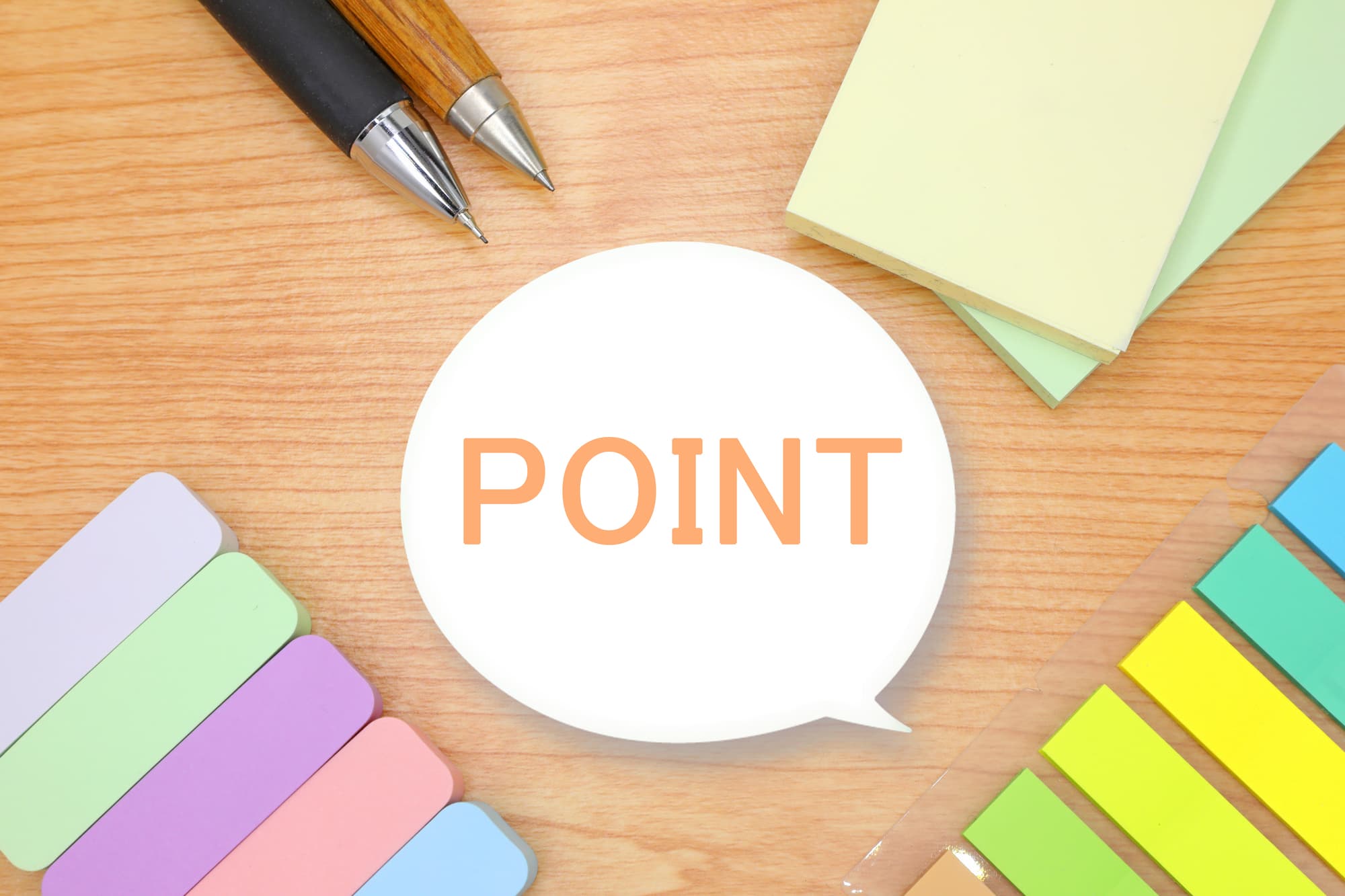 「POINT」と書かれた吹き出しと、色とりどりの付箋、ペン