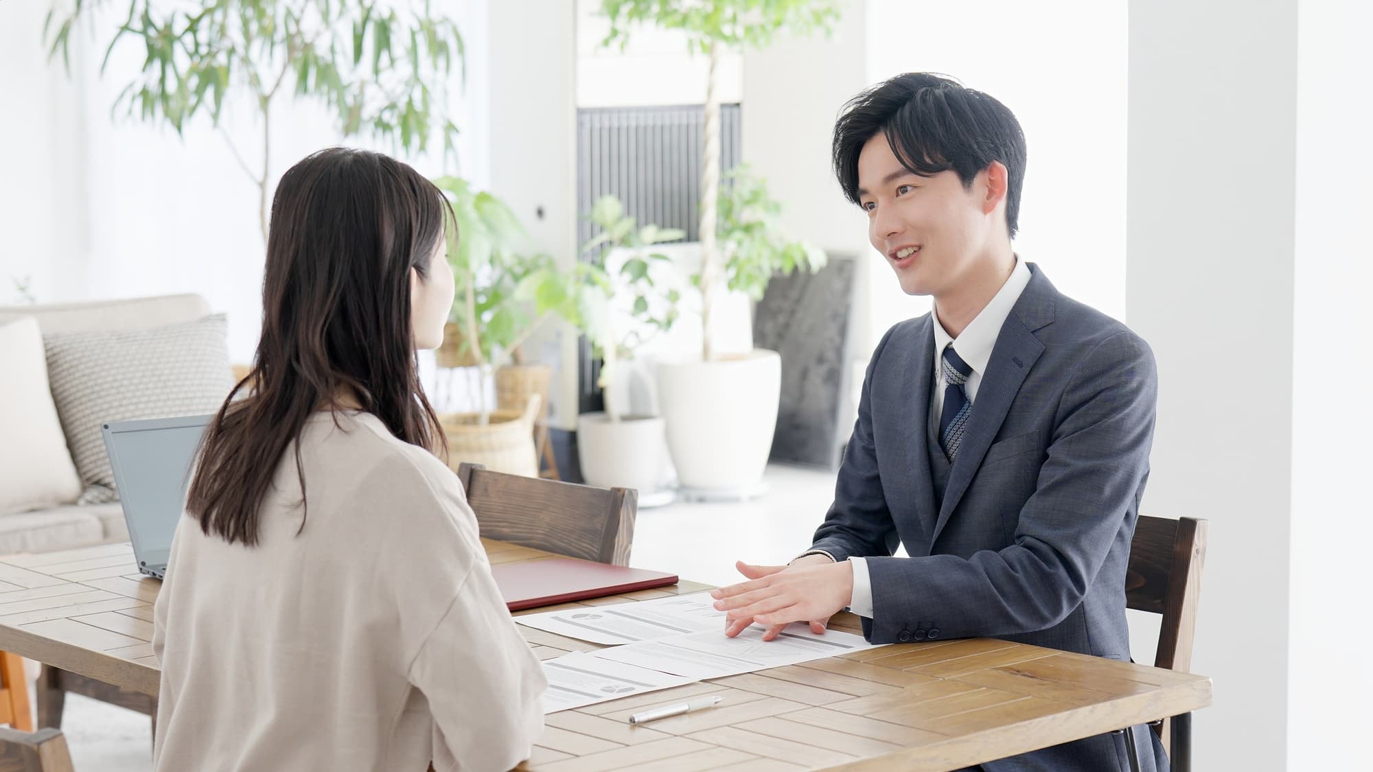 女性に説明を行うスーツ姿の男性

